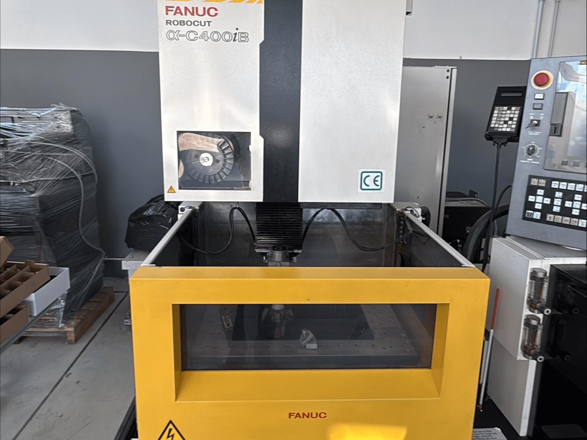 Macchina per elettroerosione a filo FANUC Robocut α-C400iB, vista frontale, con serbatoio giallo e pannello di controllo.