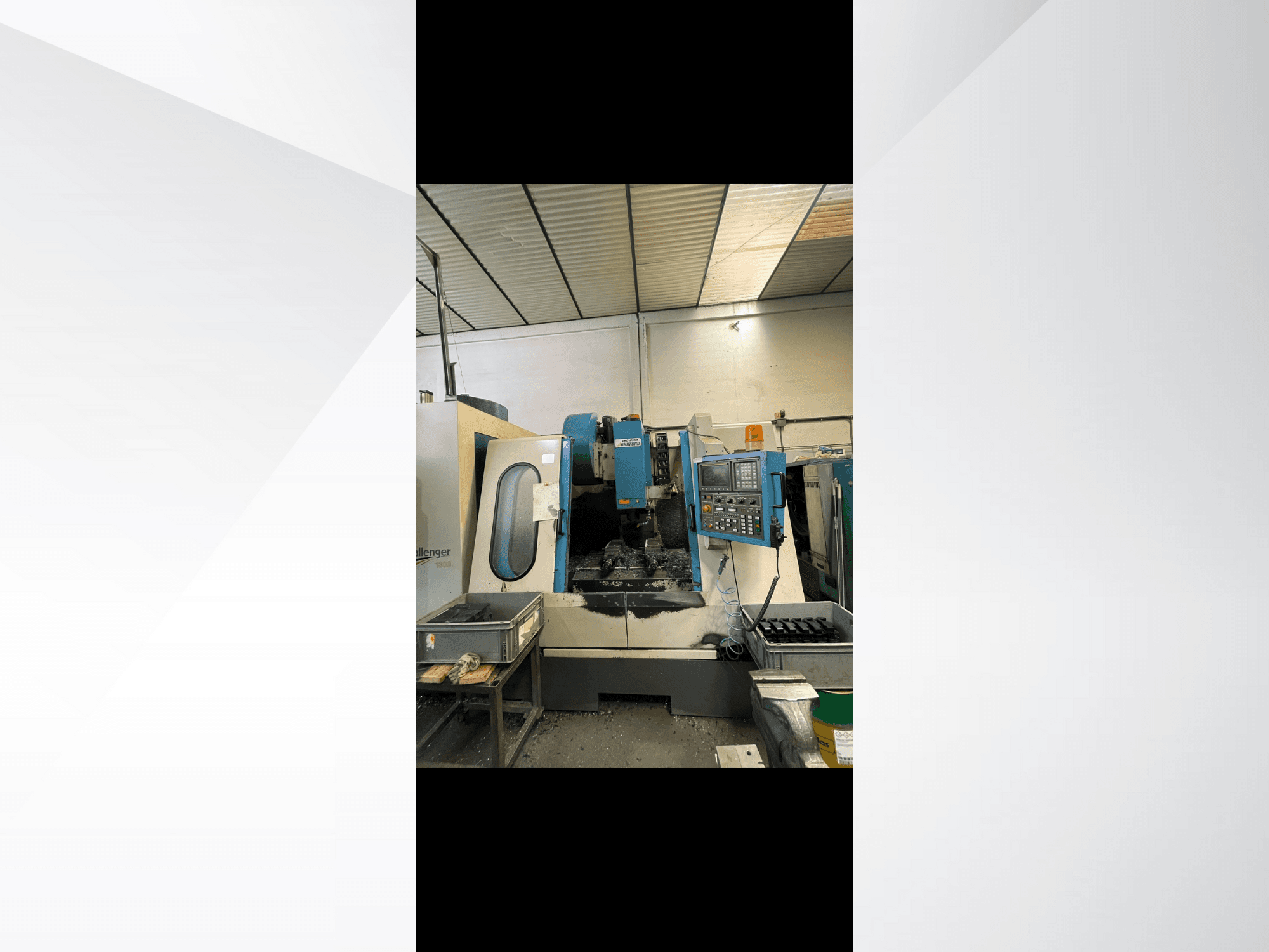Macchina CNC, modello Challenger 1500, vista laterale che mostra il pannello di controllo e l'area di lavoro con trucioli di metallo.