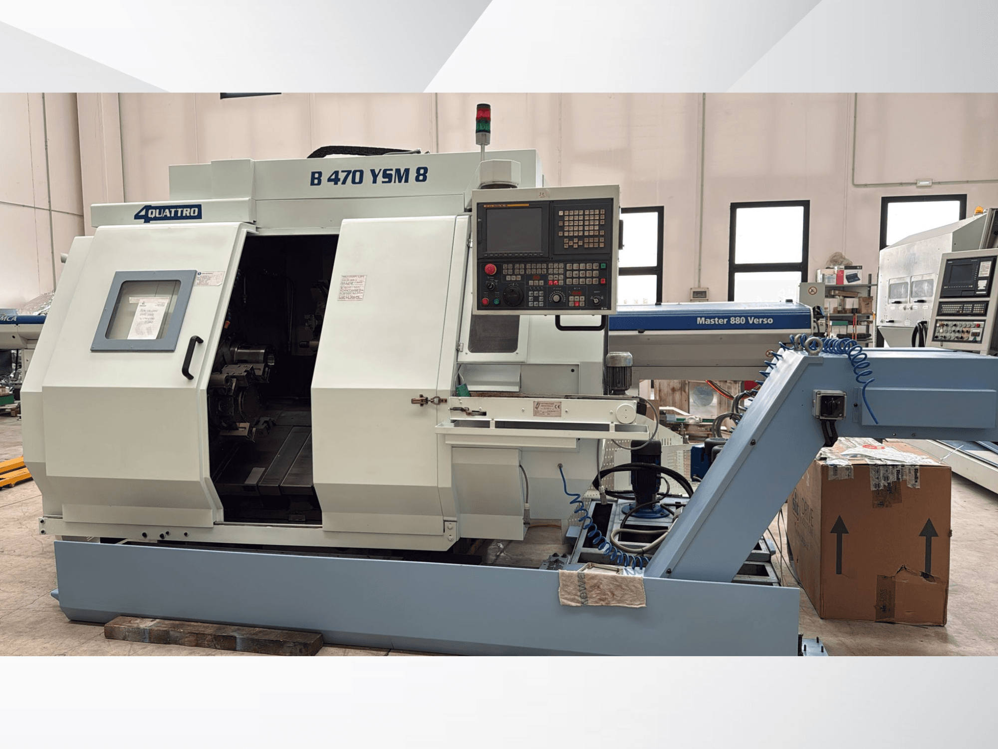 Centro di tornitura Biglia B470 YSM, vista frontale che mostra il pannello di controllo, il portello aperto e l'area di lavoro con gli utensili all'interno.