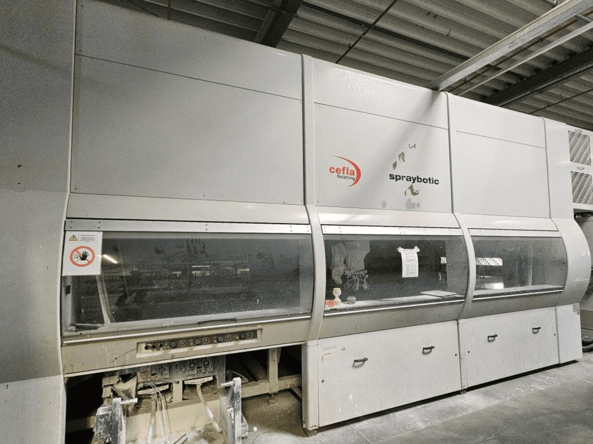 Linea di produzione Cefla Spraybotic MD per legno, vista frontale, con pannello di controllo e vetrine trasparenti.