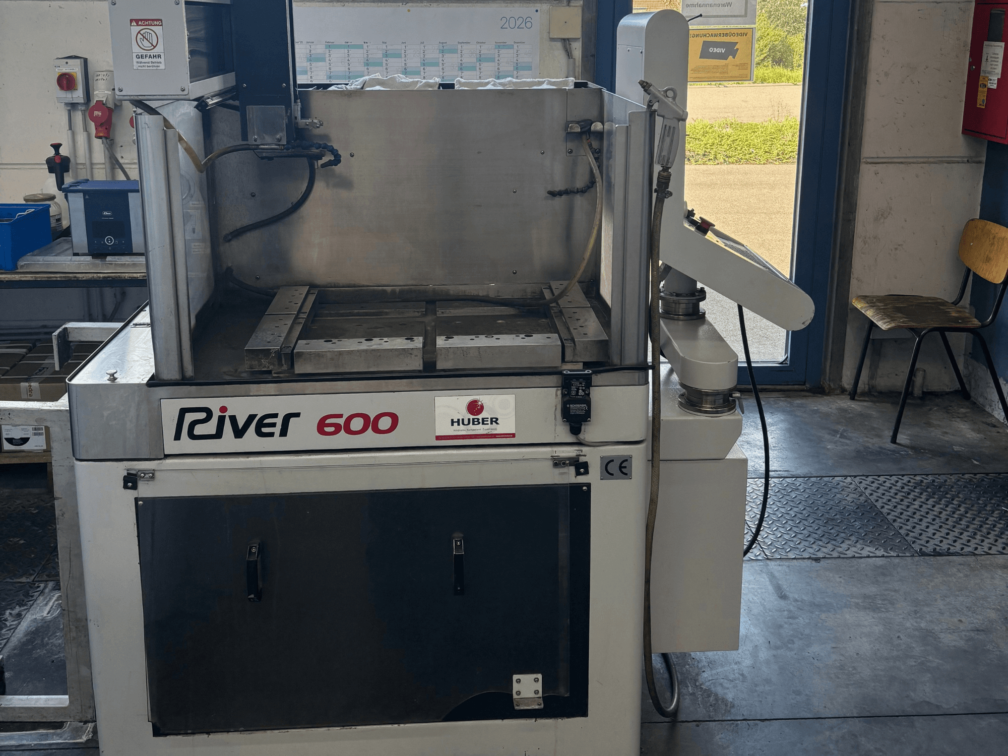 Macchina per elettroerosione a tuffo HUBER River 600 CNC, vista frontale, con camera di lavorazione parzialmente aperta e pannello di controllo.