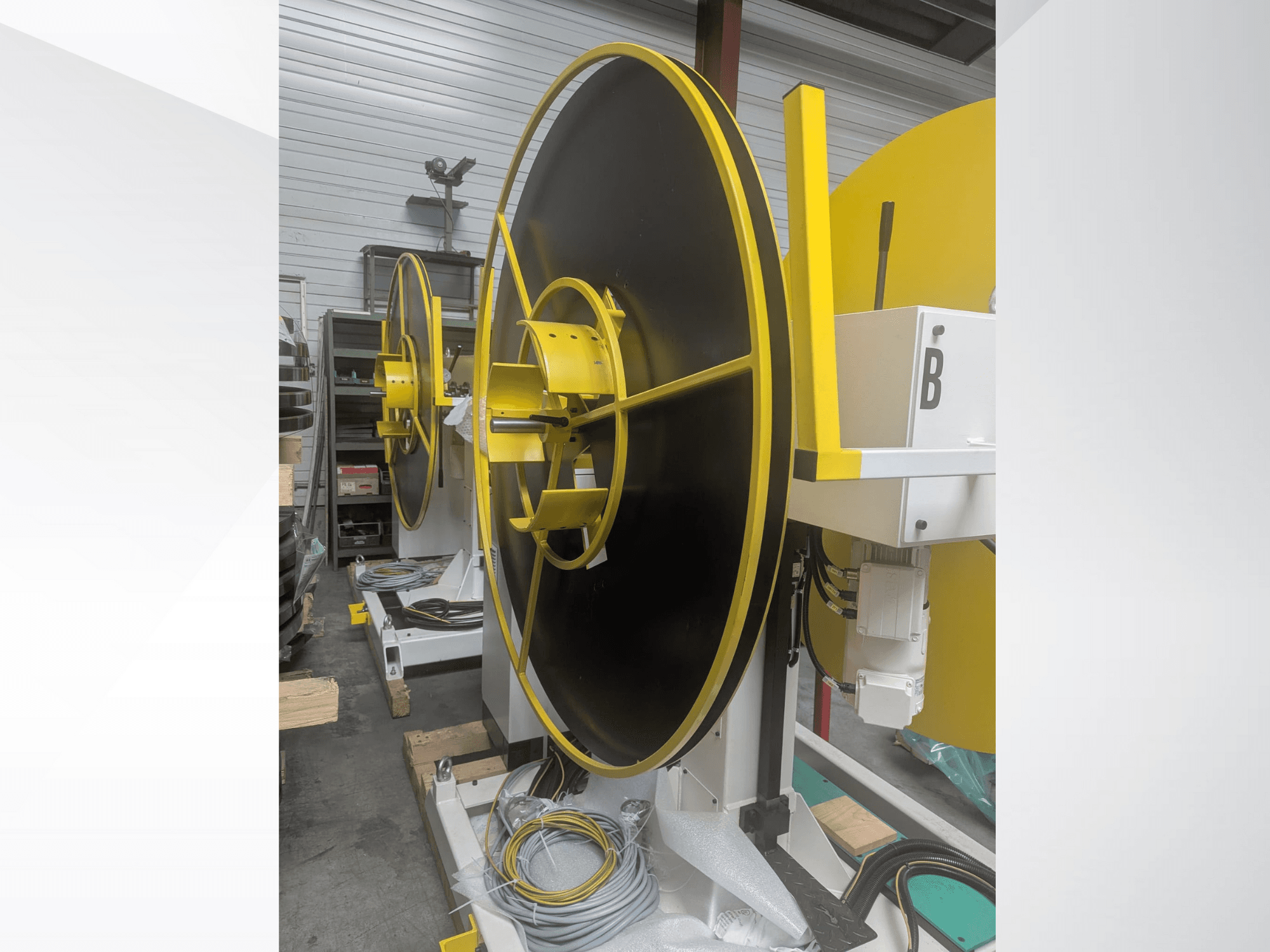 Grande bobina industriale, modello XYZ, con superficie nera e accenti gialli, vista di lato, con collegamenti elettrici.