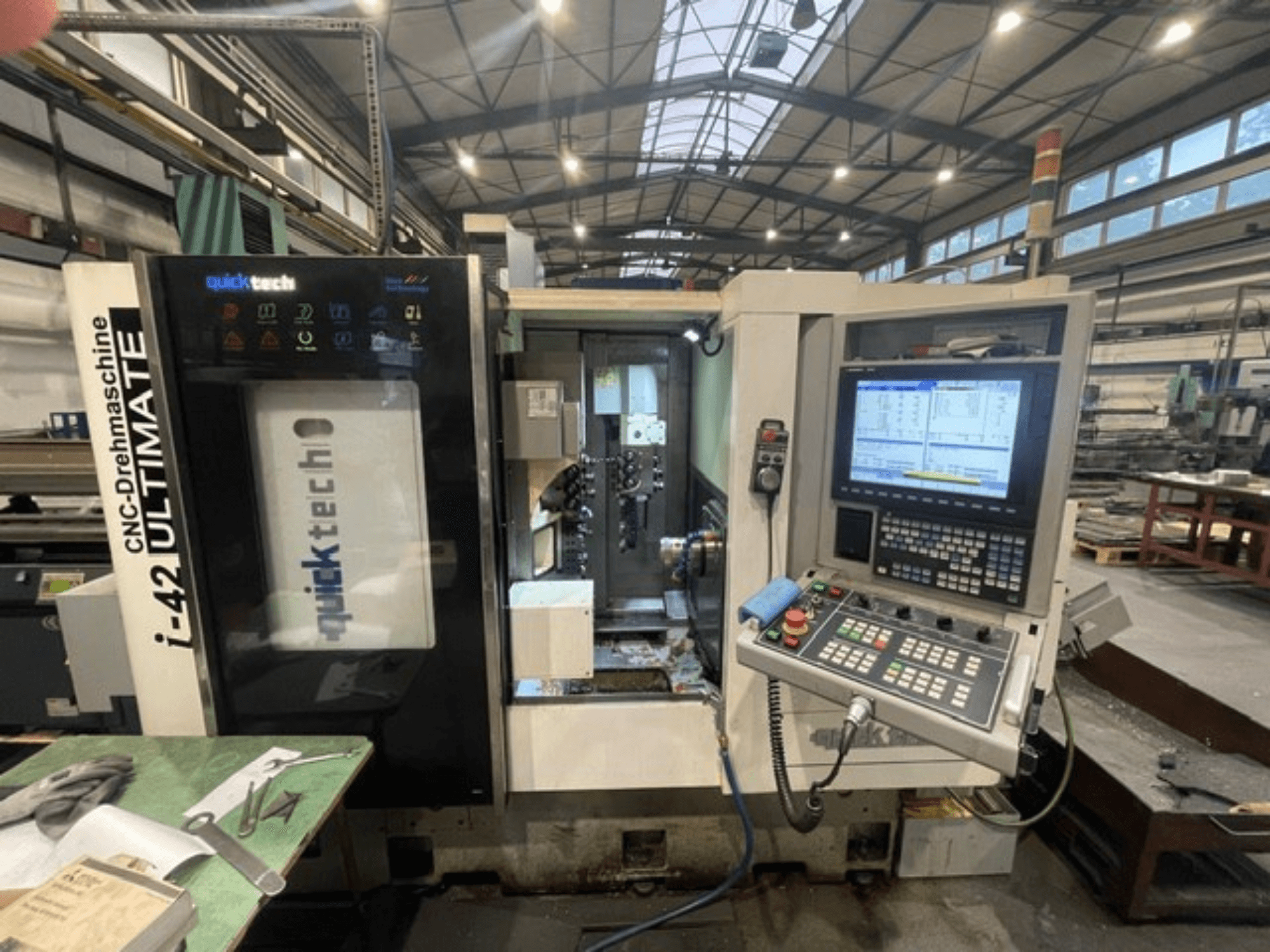 Tornio Quick-Tech I-42U di tipo svizzero, vista frontale, che mostra il pannello di controllo e l'interfaccia CNC in un ambiente di officina.