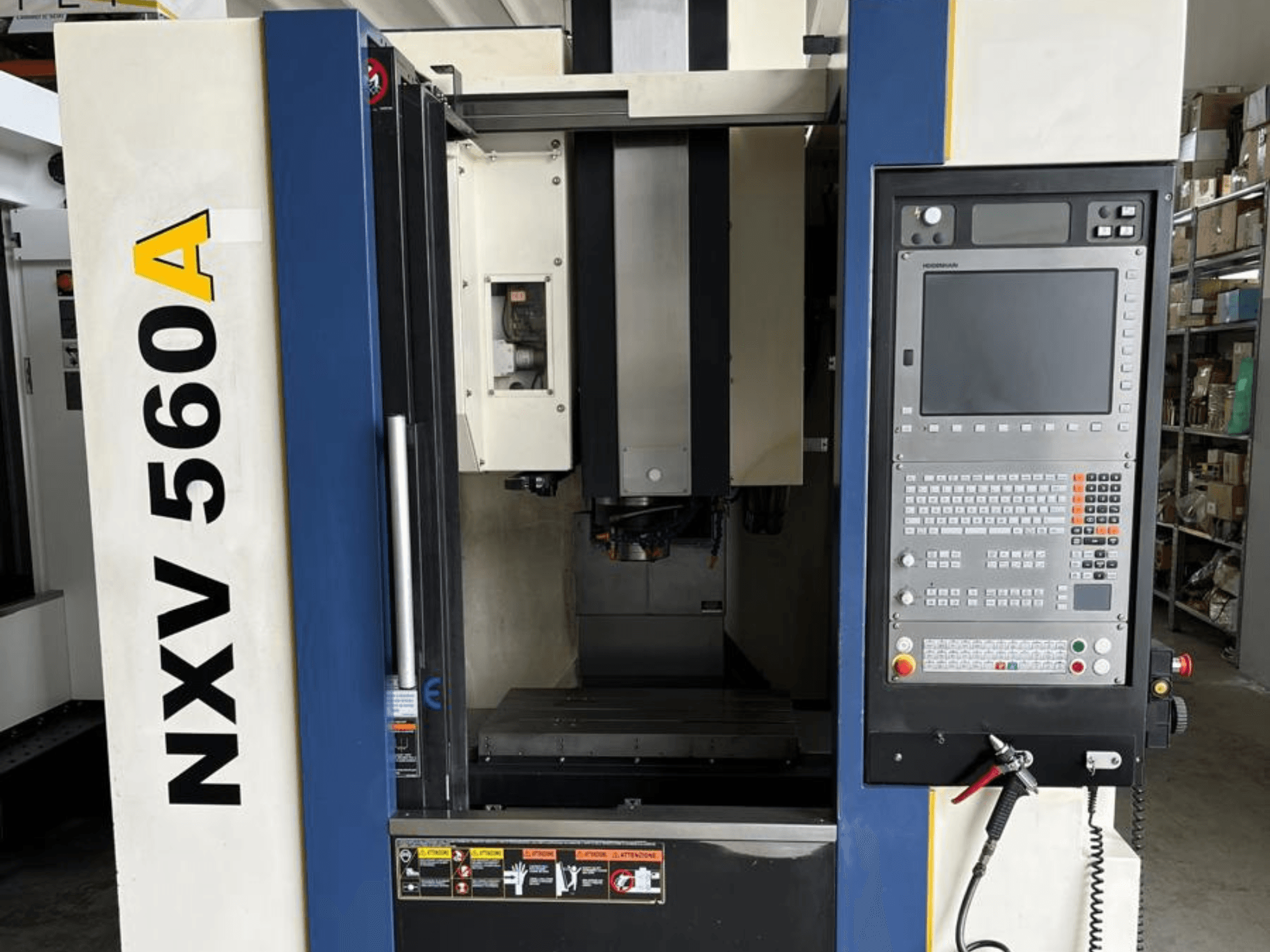 Macchina CNC NXV 560A vista frontalmente, con pannello di controllo dotato di pulsanti e display digitale.