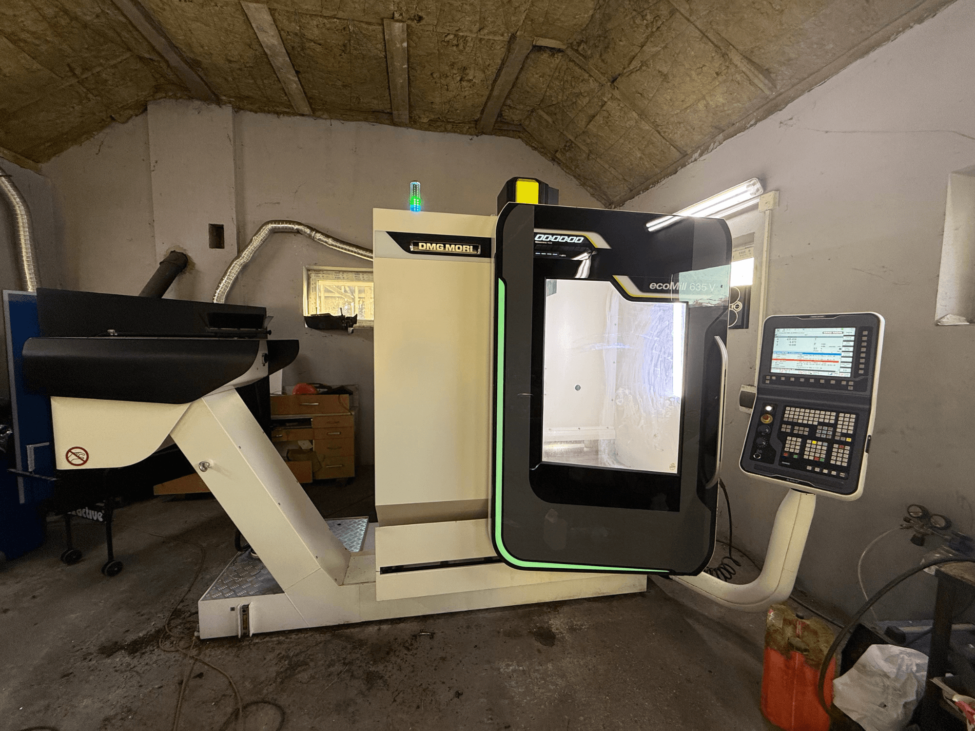 Centro di lavoro verticale DMG 635 V Ecoline, vista frontale con pannello di controllo, che mostra l'area di lavorazione e il design moderno.