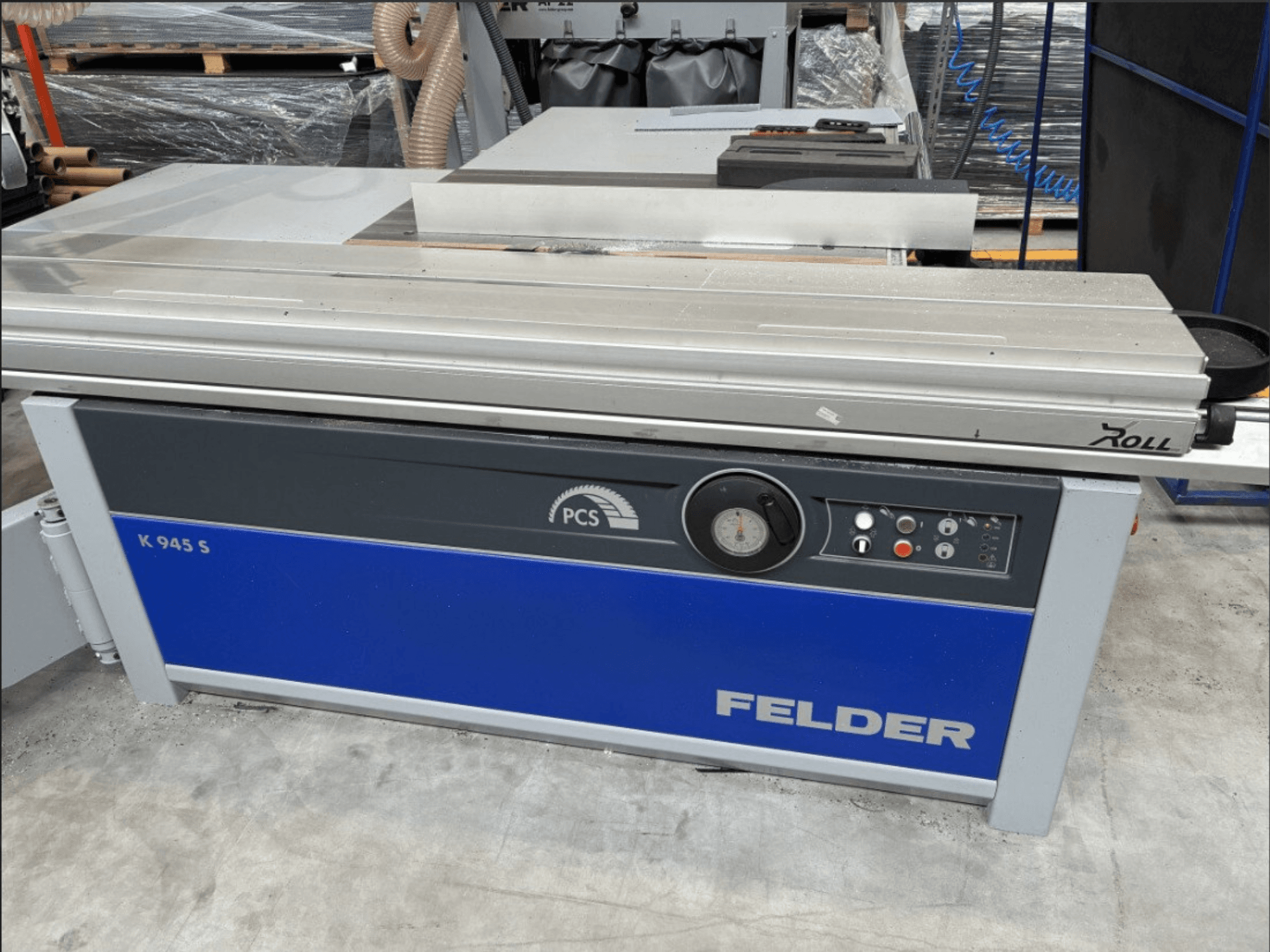 Sega circolare FELDER K 945 S, vista frontale che mostra il pannello di controllo, il piano di lavoro e i dispositivi di sicurezza, posizionata sul pavimento di un'officina.