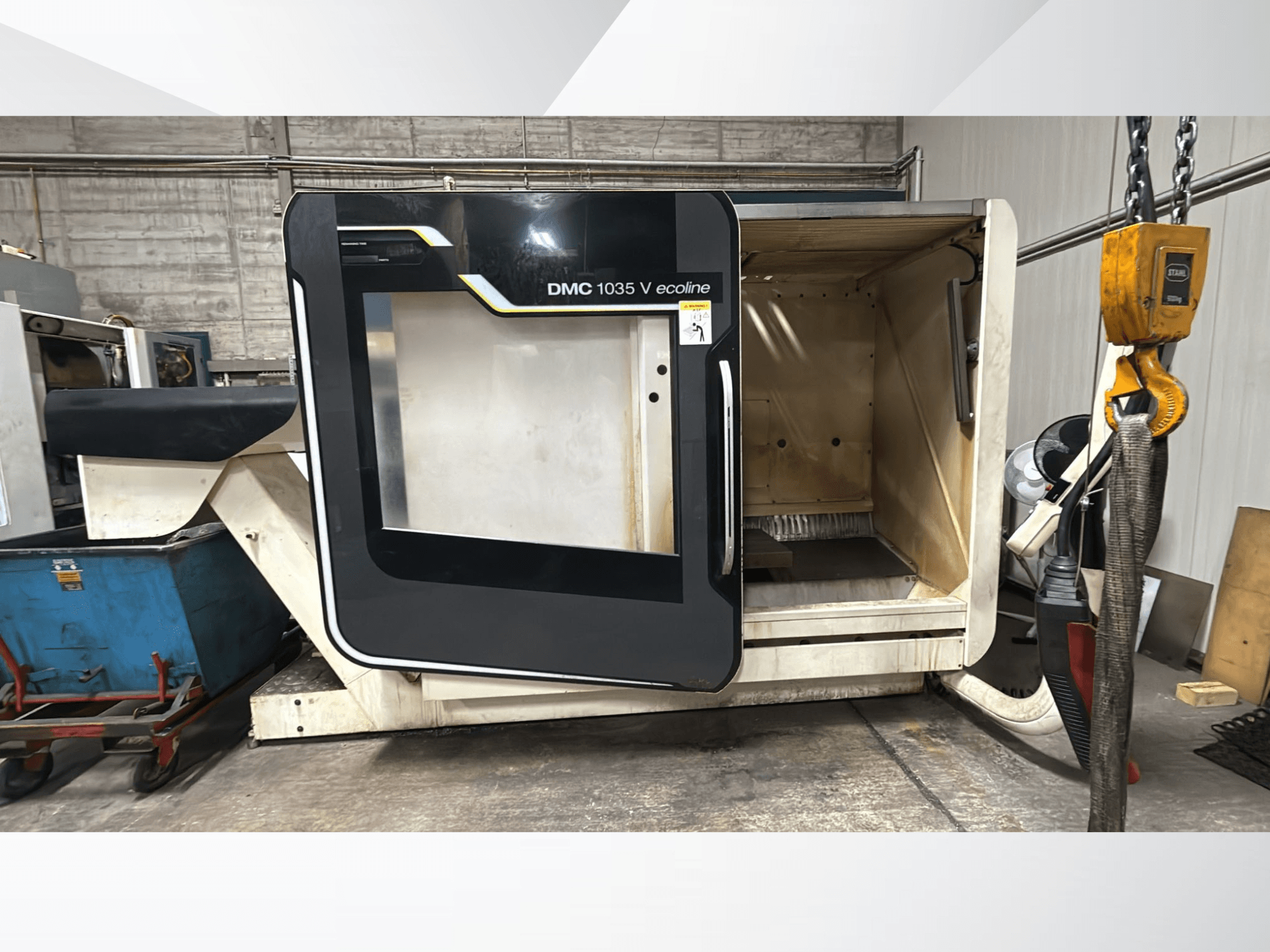 Macchina CNC DMC 1035 V ecoline, vista frontale, con porta aperta che rivela un interno vuoto e un pannello di controllo.