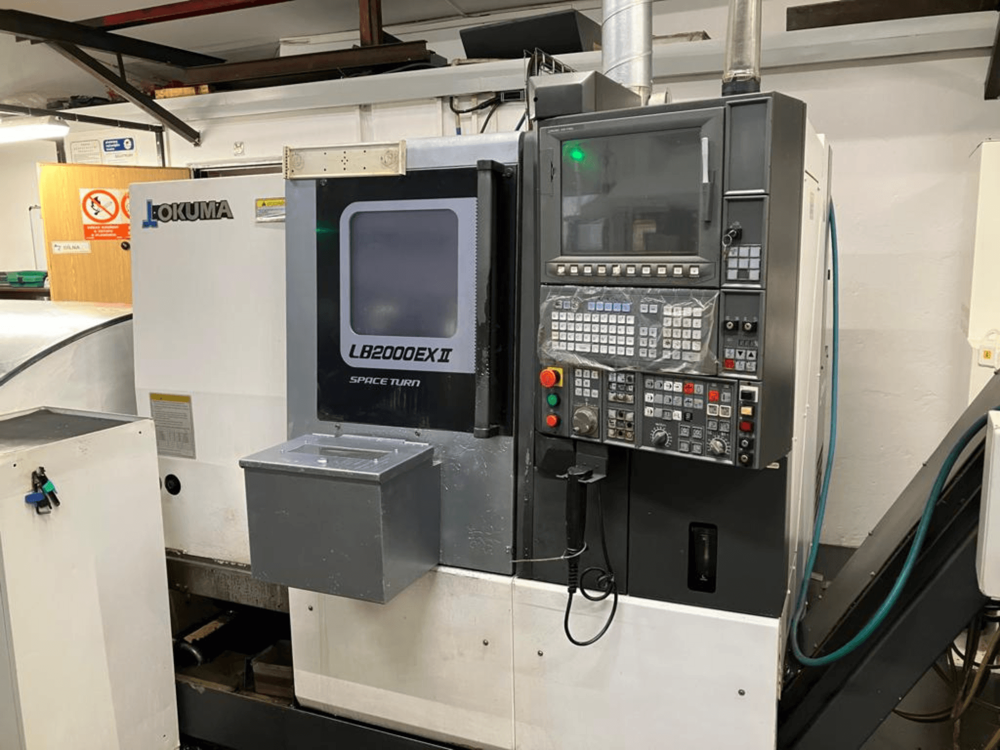 Tornio orizzontale Okuma LB2000EXII MC, vista frontale che mostra il pannello di controllo e le caratteristiche operative.