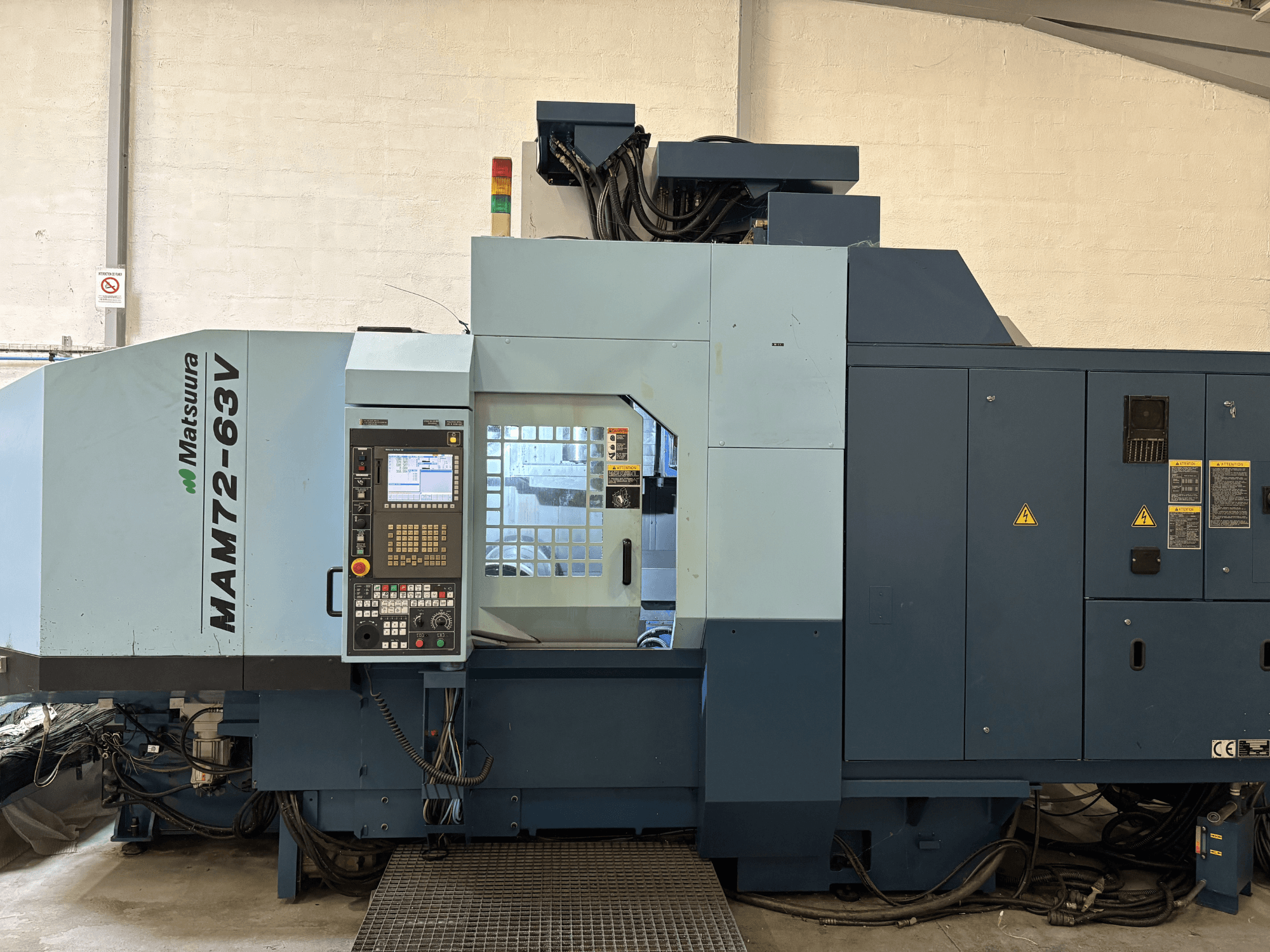 Centro di lavoro verticale Matsuura MAM 72-63 V, vista frontale che mostra il pannello di controllo e le caratteristiche di sicurezza.