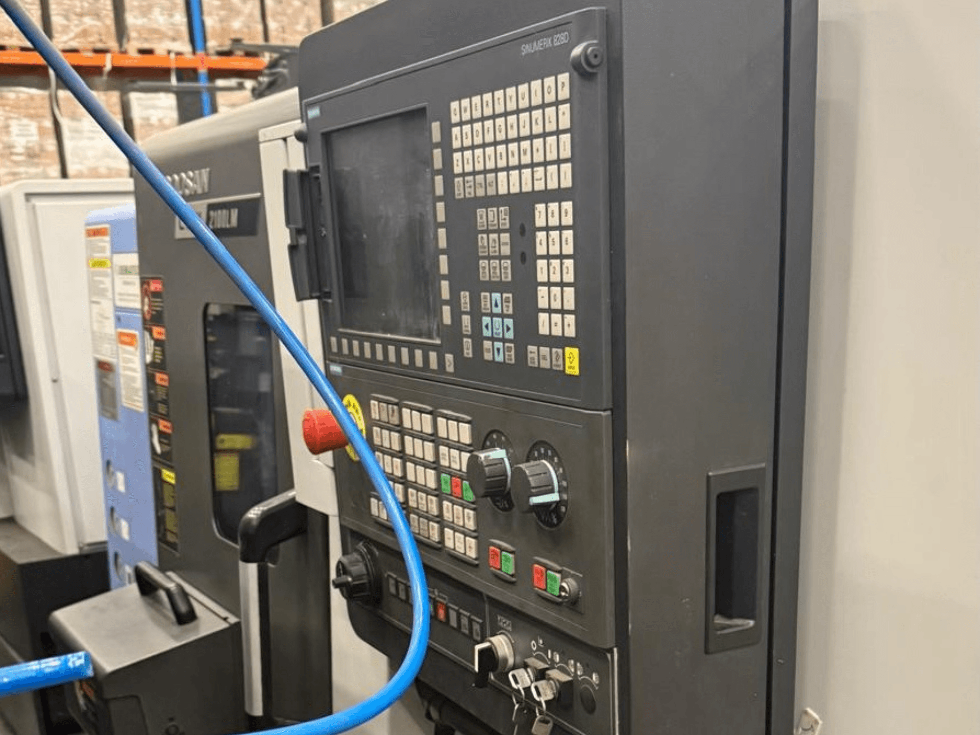 Pannello di controllo di un utensile di lavorazione, vista frontale, con pulsanti, manopole e un display digitale per un funzionamento preciso.