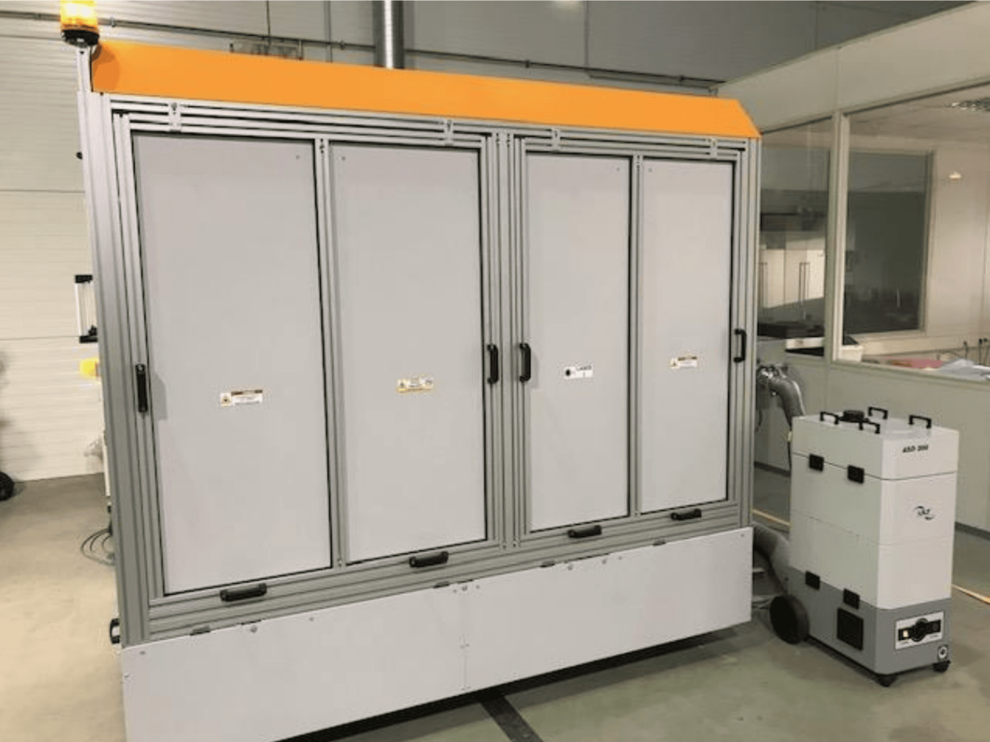 Macchina da taglio laser in fibra 4JET Pearl M, vista frontale, con luce di sicurezza, pannello di controllo e unità di estrazione collegata visibili.