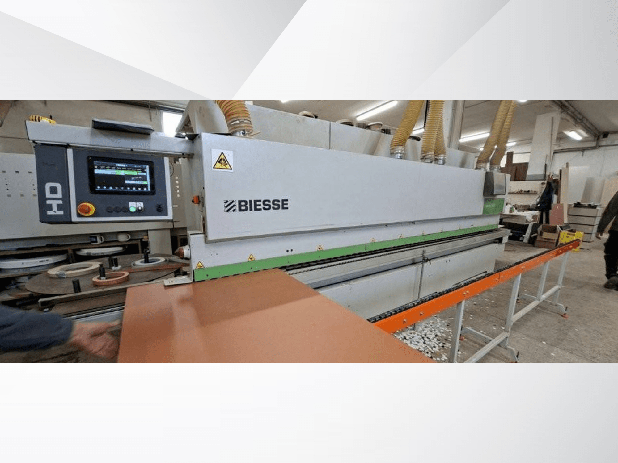 Bordatrice BIESSE JADE 340 in un'officina, vista frontale con pannello di controllo digitale e tavolo di alimentazione arancione.