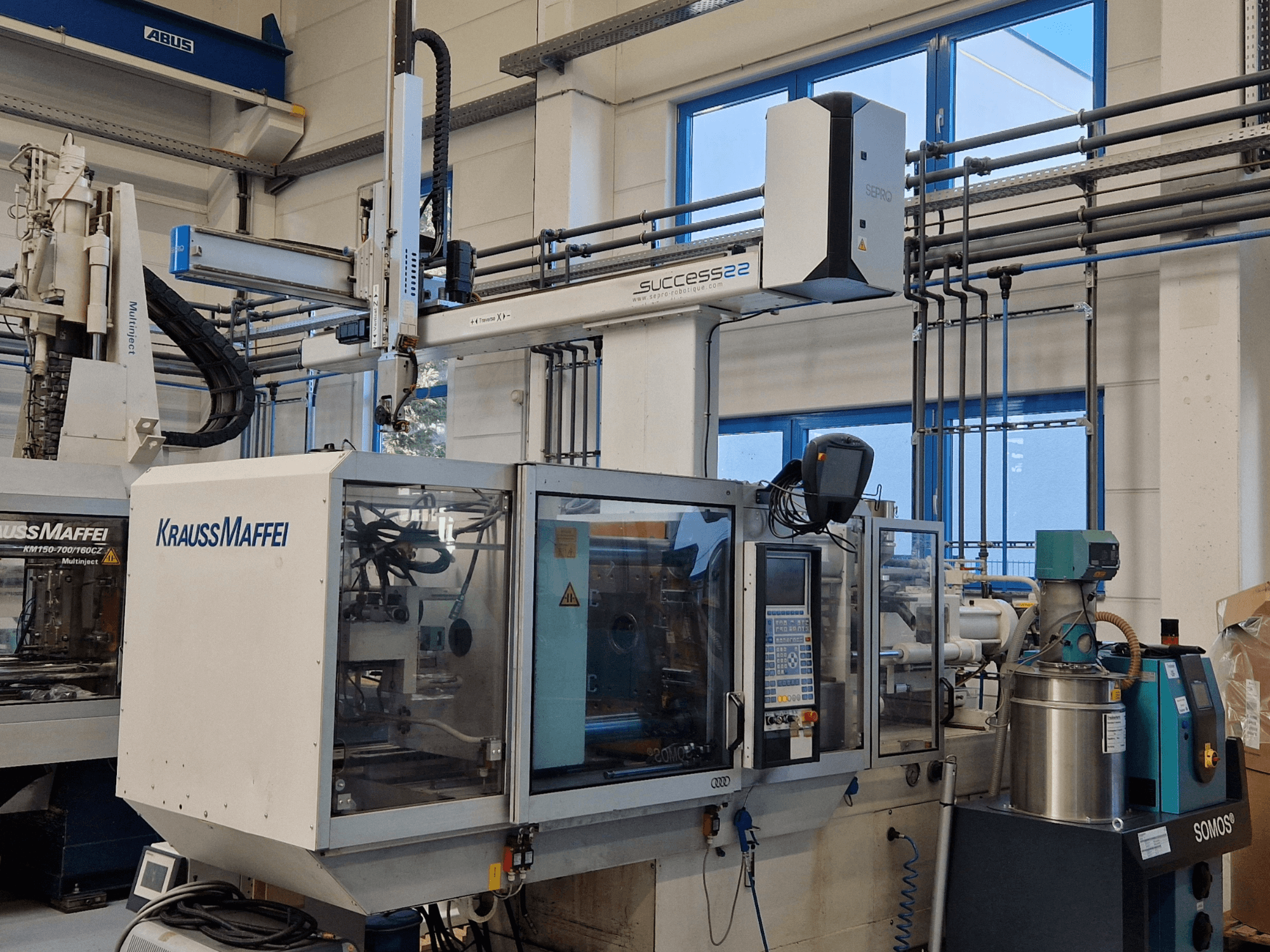 Pressa a iniezione KraussMaffei Success 22 con pannello di controllo, vista frontalmente in un ambiente di fabbrica.
