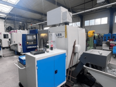 Officina industriale con centro di lavoro Heller, vista frontale che mostra utensili, comandi e attrezzature circostanti.