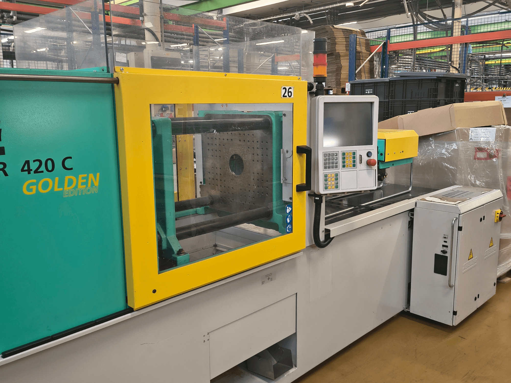 Pressa ad iniezione, ARBURG 420 C Golden Edition, vista frontale; presenta pannello di controllo, protezione di sicurezza trasparente e spazio di lavoro circostante.