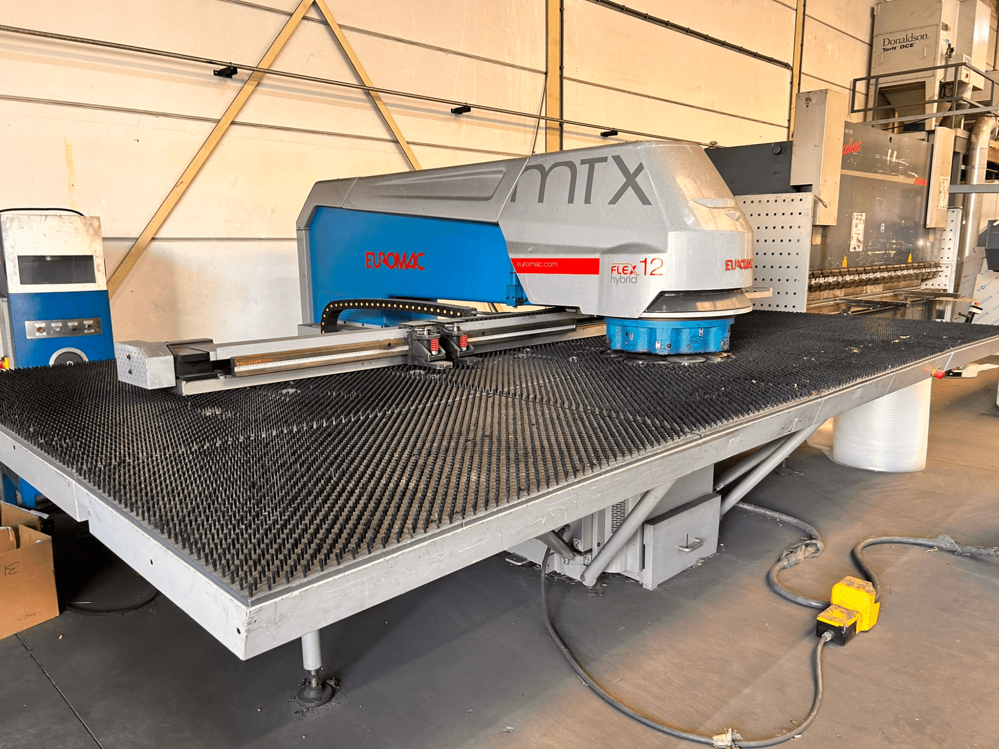 Punzonatrice CNC Euromac MTX FLEX 12, vista frontale, dotata di un ampio tavolo forato e di un pannello di controllo.
