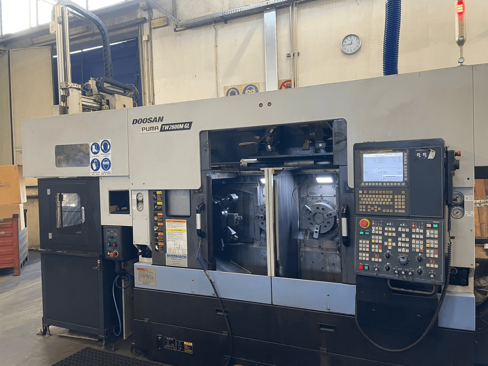 Tornio CNC Doosan Puma TW2600M GL, vista frontale, che mostra il pannello di controllo digitale e l'interno della macchina con i portautensili.