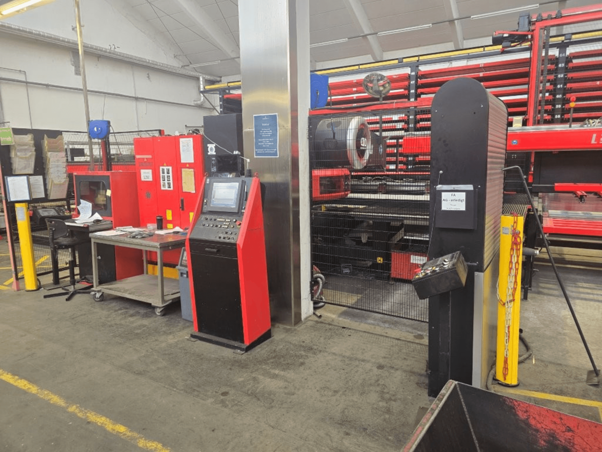 Vista frontale della punzonatrice CNC AMADA EMZ 3610 NT, con i comandi dell'operatore e la cabina di sicurezza in un ambiente di fabbrica.