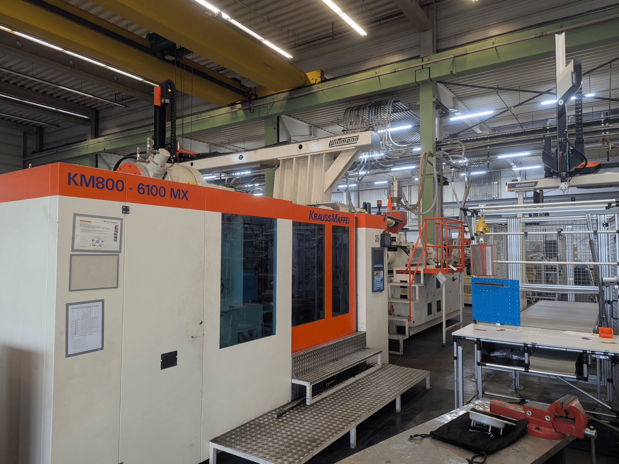 Macchina ad iniezione idraulica Krauss Maffei KM 800-6100MX, vista frontale, con pannello di controllo e configurazione industriale.