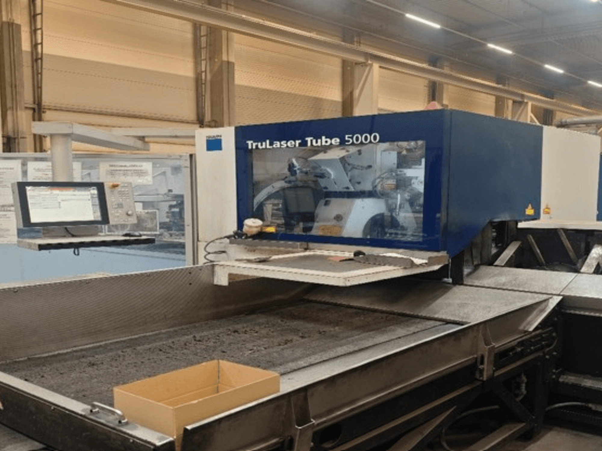 TRUMPF TruLaser Tube 5000 vista frontale, con il pannello di controllo e l'area di taglio che consentono operazioni di taglio dei tubi di precisione.