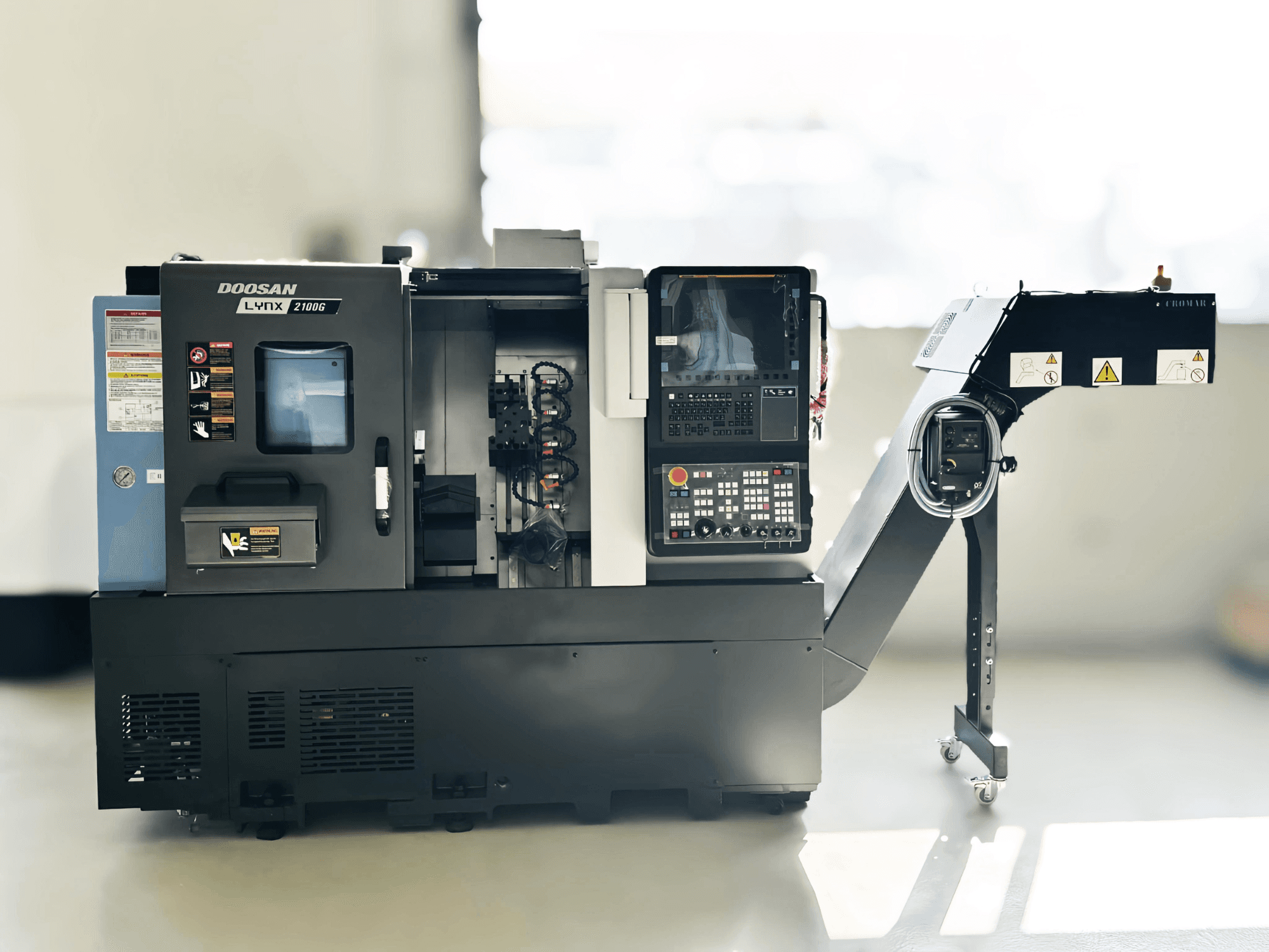 Tornio di tipo svizzero DOOSAN LYNX 2100GA in vista laterale con pannello di controllo e portautensili visibili.