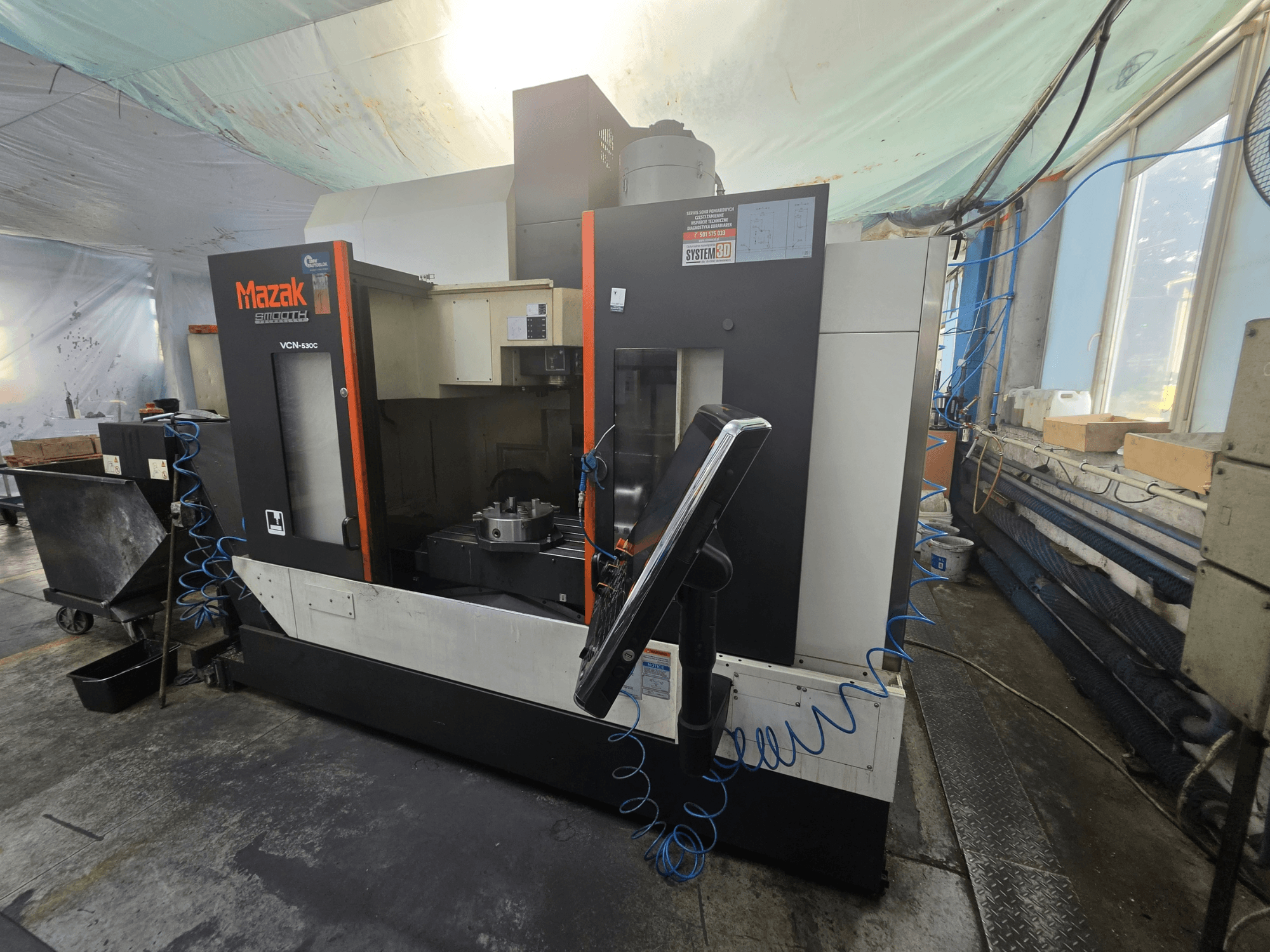 Centro di lavorazione verticale Mazak VCN-530C visto frontalmente, con in primo piano il pannello di controllo, l'area di lavoro e il portautensili.