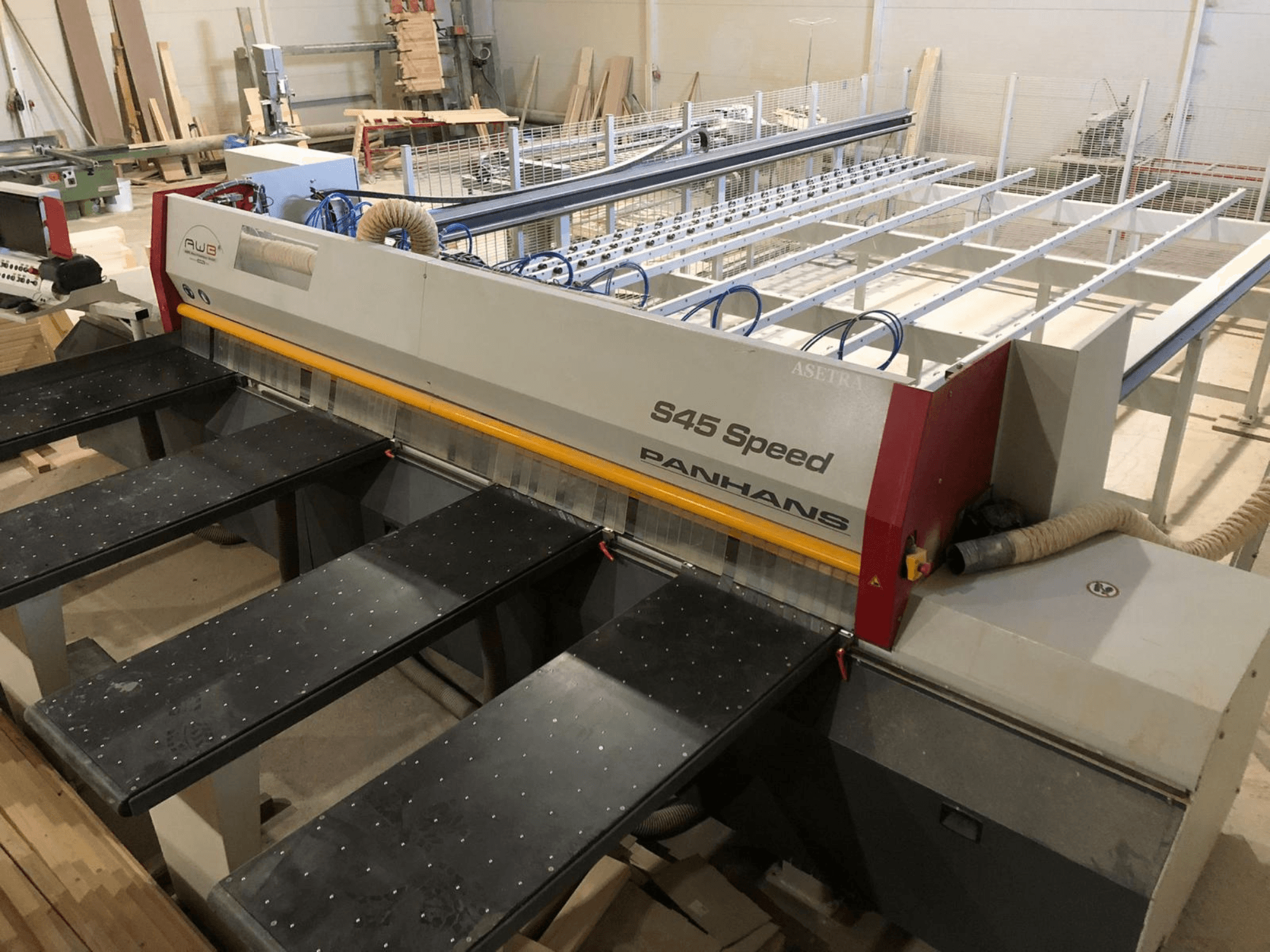 Vista laterale di una sezionatrice PANHANS S45 Speed, con configurazione a cinque tavoli e pannello di controllo visibile con aspirazione della polvere.