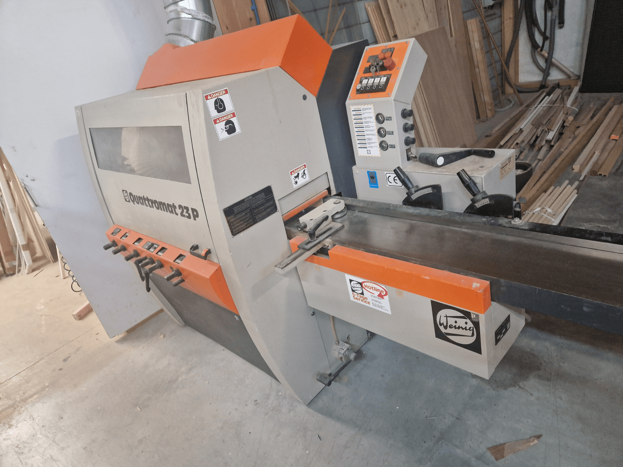 Modello Weinig Quadtr الضوم 23 P, vista frontale di una fresatrice per legno con pannello di controllo e avvertenze di sicurezza.