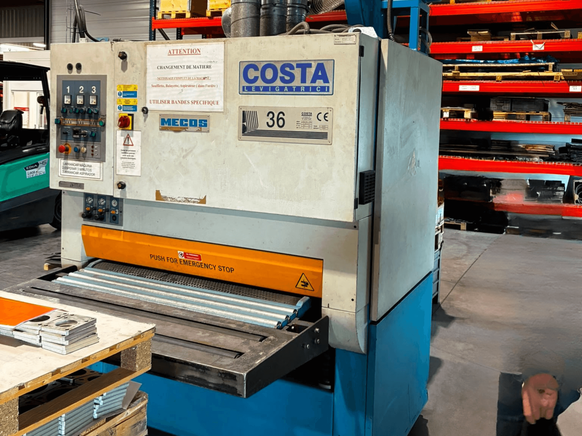 Sbavatrice Costa M36 CCS 1150 vista laterale, con pannello di controllo, pulsante di arresto di emergenza e superficie del trasportatore.