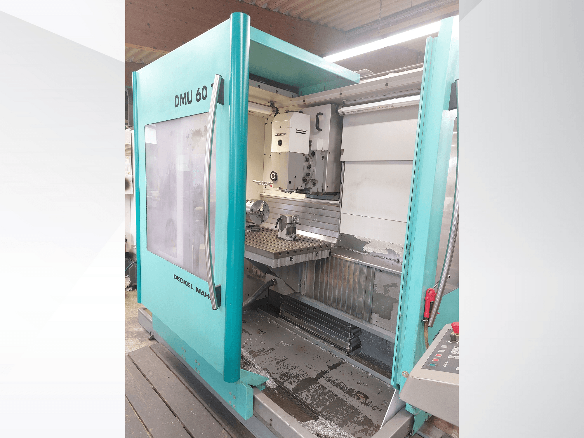 Macchina CNC Deckel MAHO DMU 60, vista frontale. Presenta un pannello di controllo visibile e un tavolo di fresatura con impostazione del pezzo.