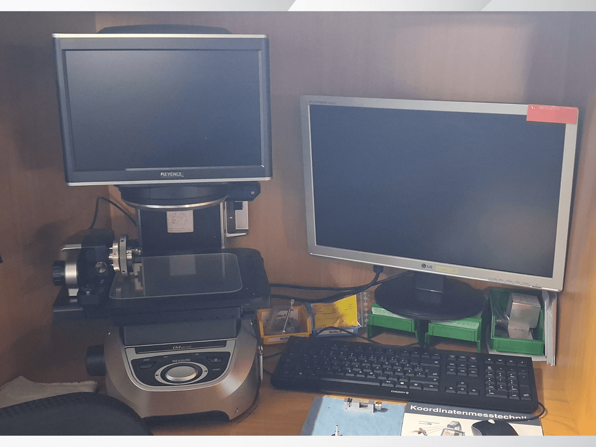 Sistema di misura Keyence con due monitor (uno LG, uno Keyence) e una tastiera, visto frontalmente.