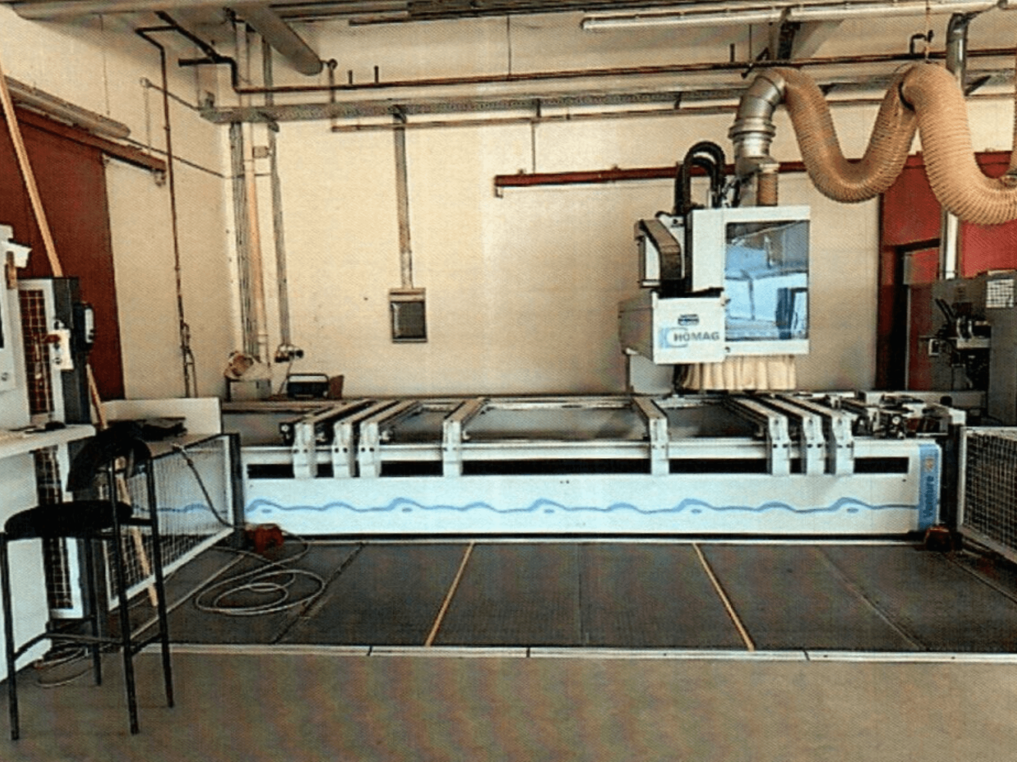 Centro di lavorazione del legno CNC HOMAG BAZ 211/40K in un'officina, che mostra il pannello di controllo e l'area di taglio della macchina.