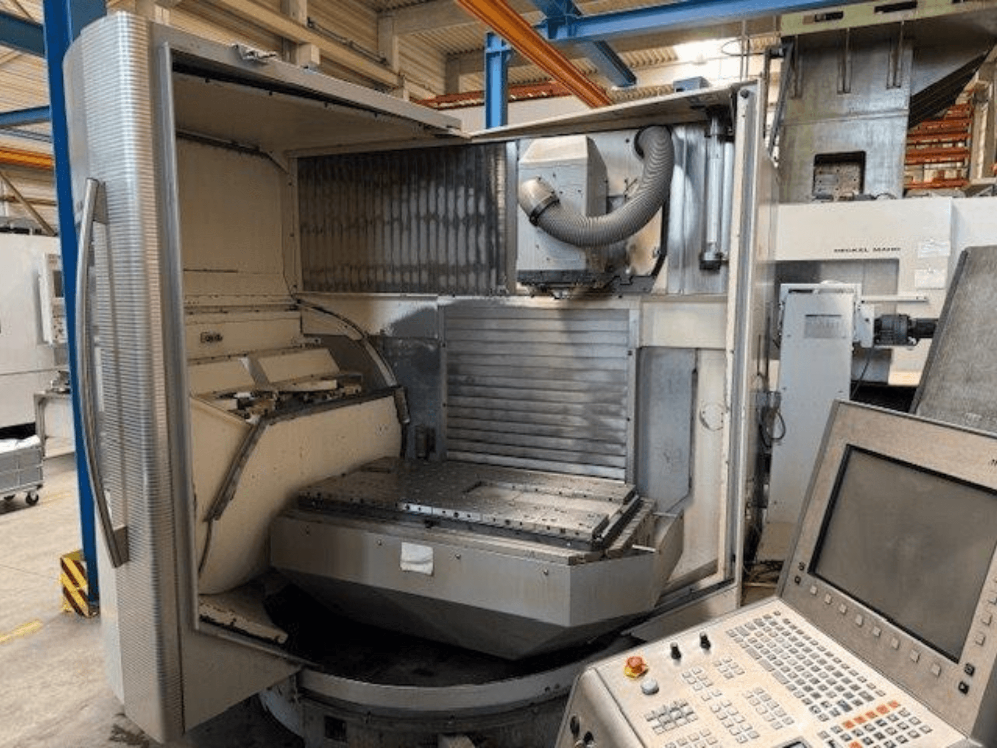 Centro di lavoro verticale DMG MORI DMU 80T, vista frontale che mostra l'involucro aperto e il pannello di controllo.