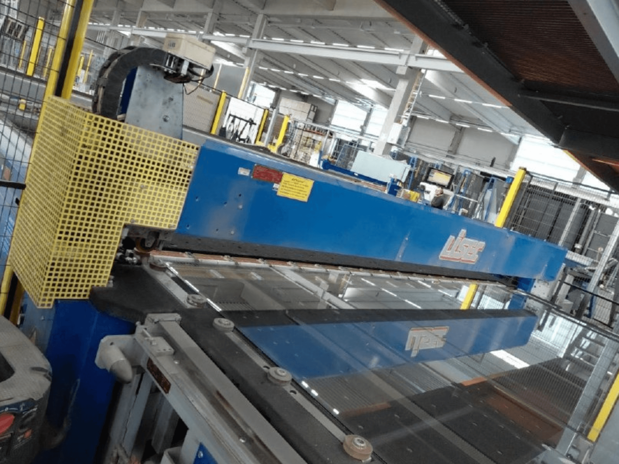 Vista frontale della linea di taglio combinata LISEC per vetro stratificato (VSG) e vetro float, con utensile da taglio blu e rete di protezione.