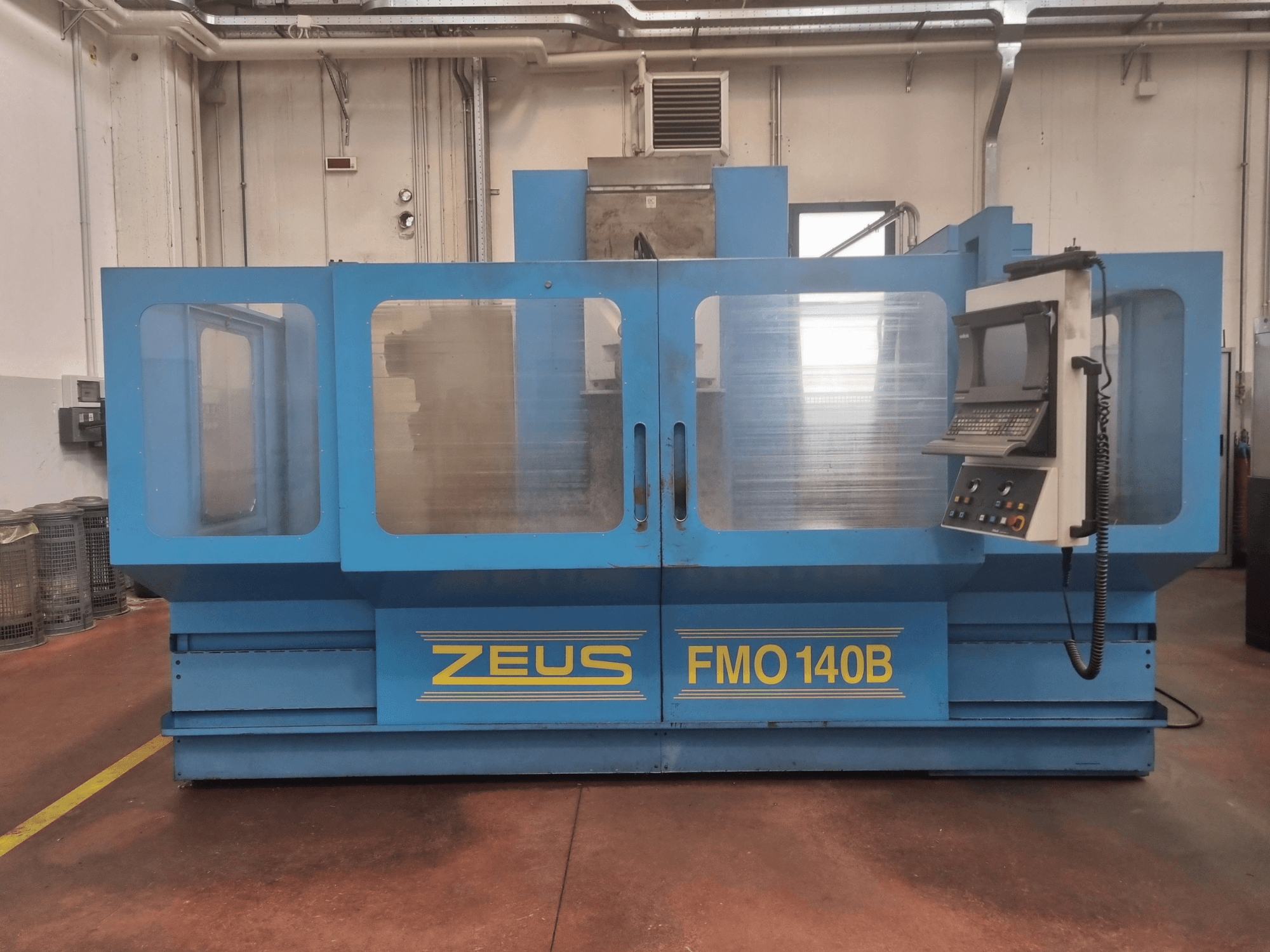 Macchina Zeus FMO 140B in blu, vista frontale; presenta un pannello di controllo e ampi pannelli trasparenti per la visibilità.