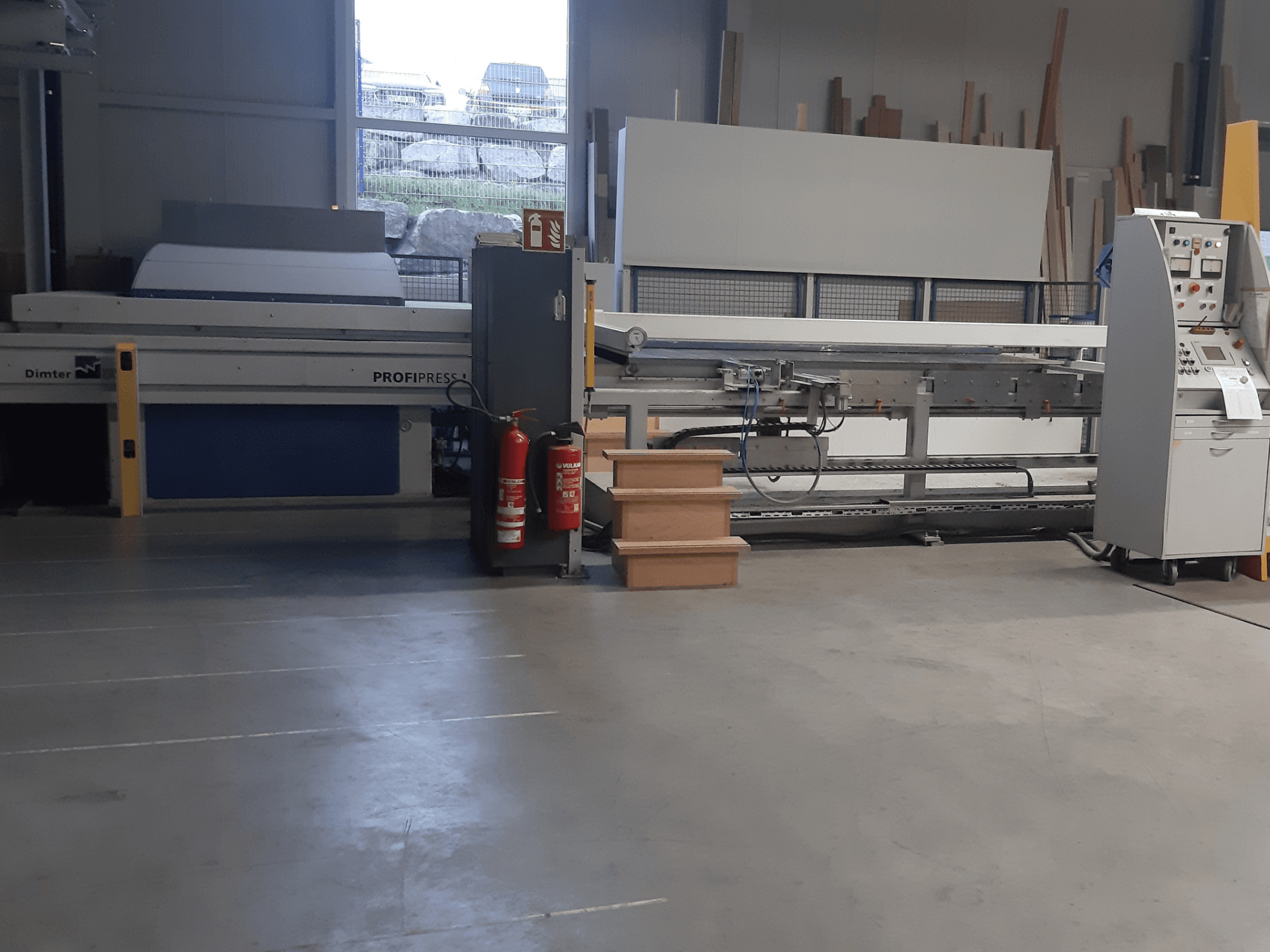 Macchina Dimter ProfiPress in un'officina, vista dal davanti, con il pannello di controllo e gli estintori nelle vicinanze.