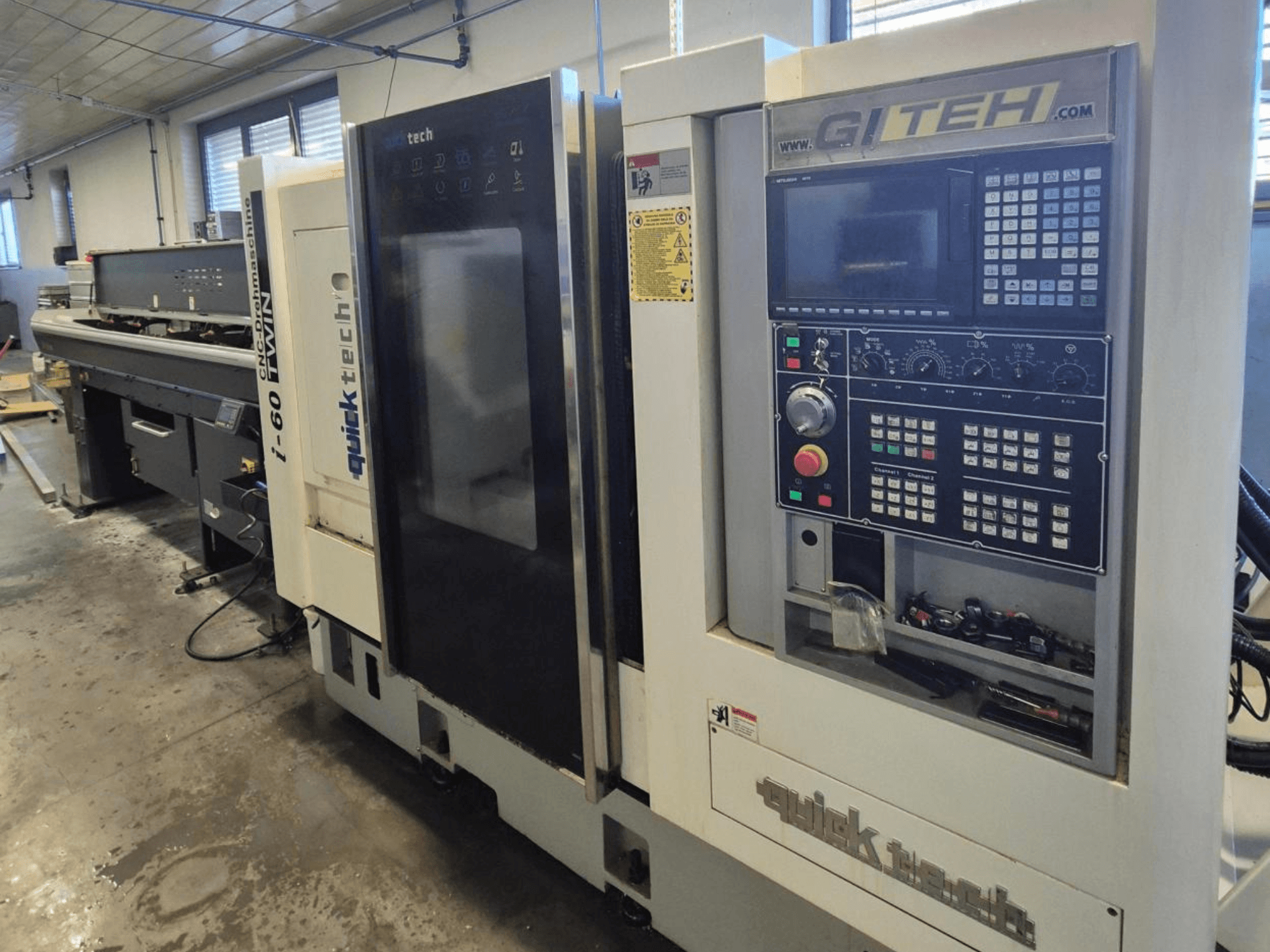 Macchina CNC doppia Quick Tech i-60, vista frontale, con pannello di controllo e pulsanti operativi GITEH, in un'officina.