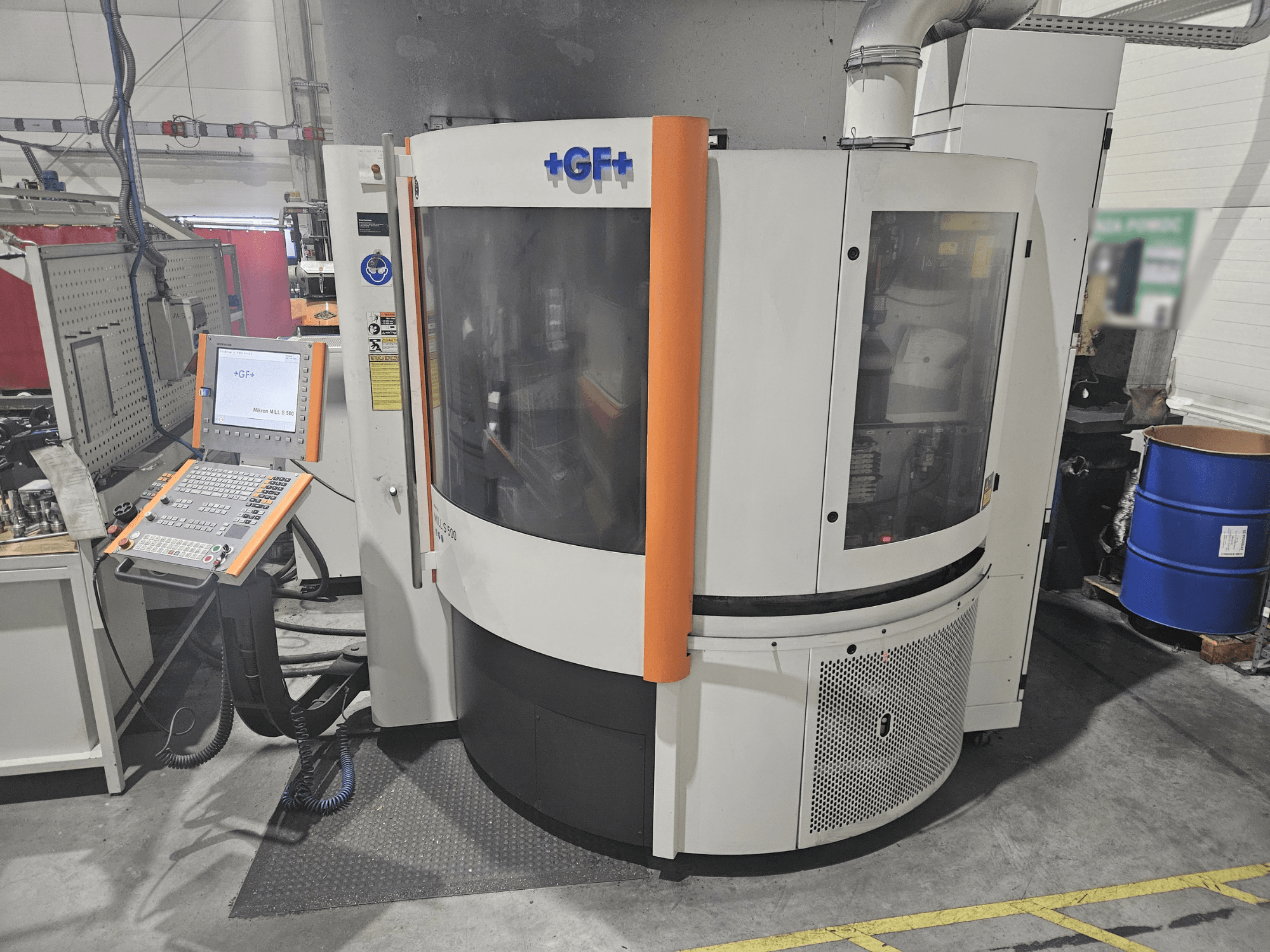 Macchina utensile GF Machining Solutions con pannello di controllo, vista frontale; presenta pannello trasparente, accenti arancioni e impostazione industriale.