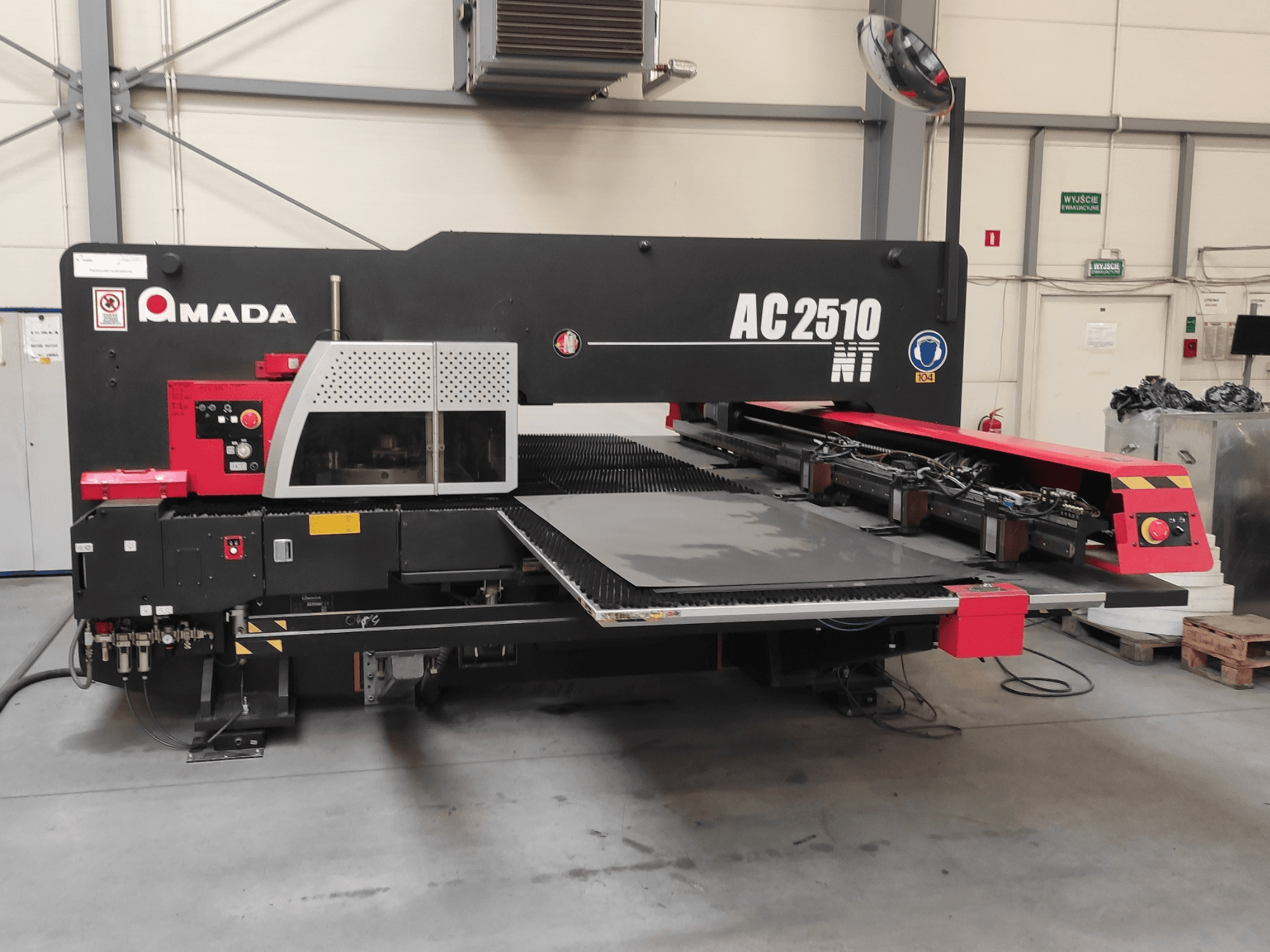 Punzonatrice CNC Amada AC2510 NT, vista frontale, con pannello di controllo e area di caricamento delle lastre.