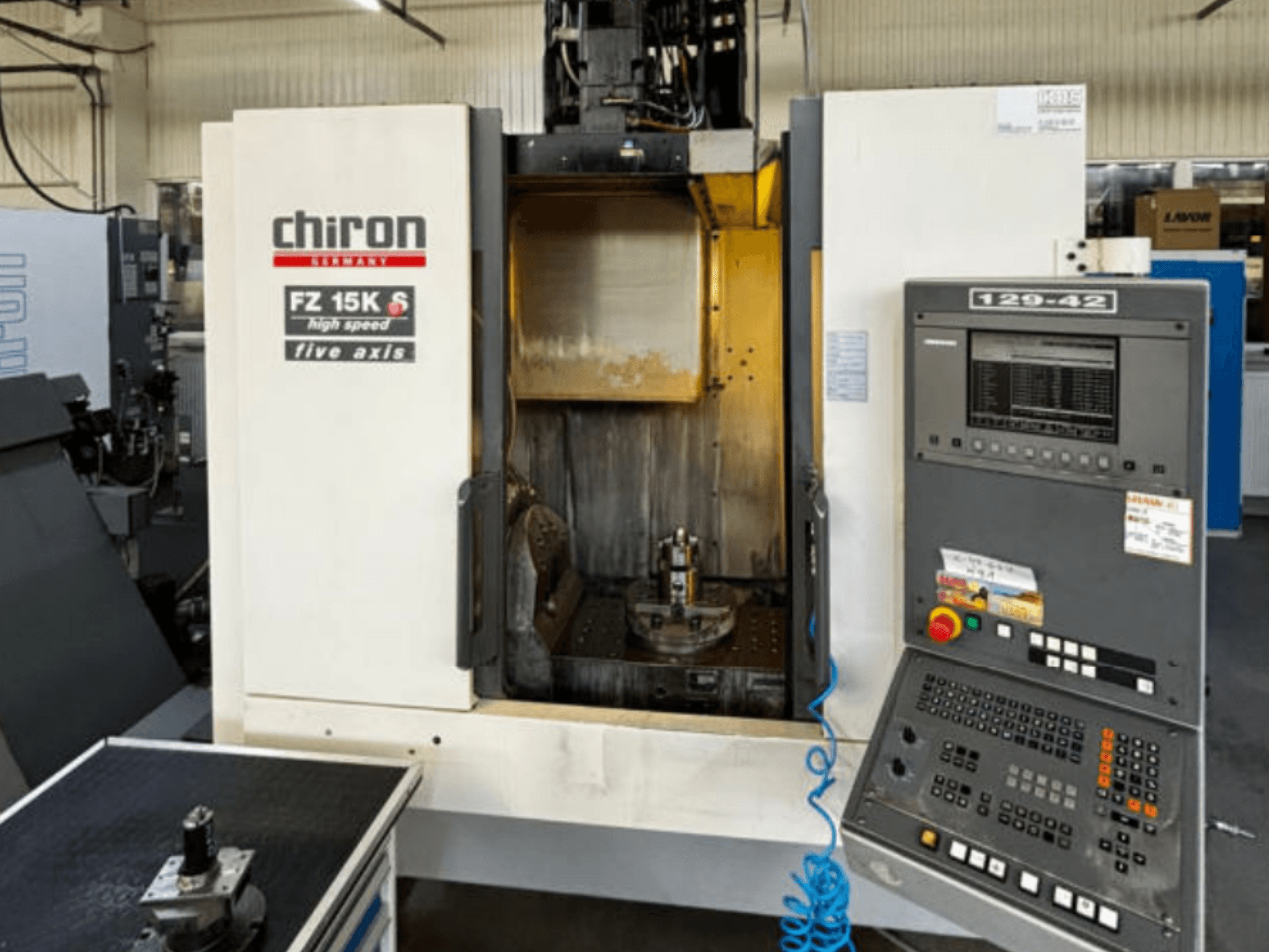 Centro di lavorazione verticale CHIRON FZ 15K S, vista frontale, con particolare attenzione al pannello di controllo e alla configurazione degli utensili a cinque assi.