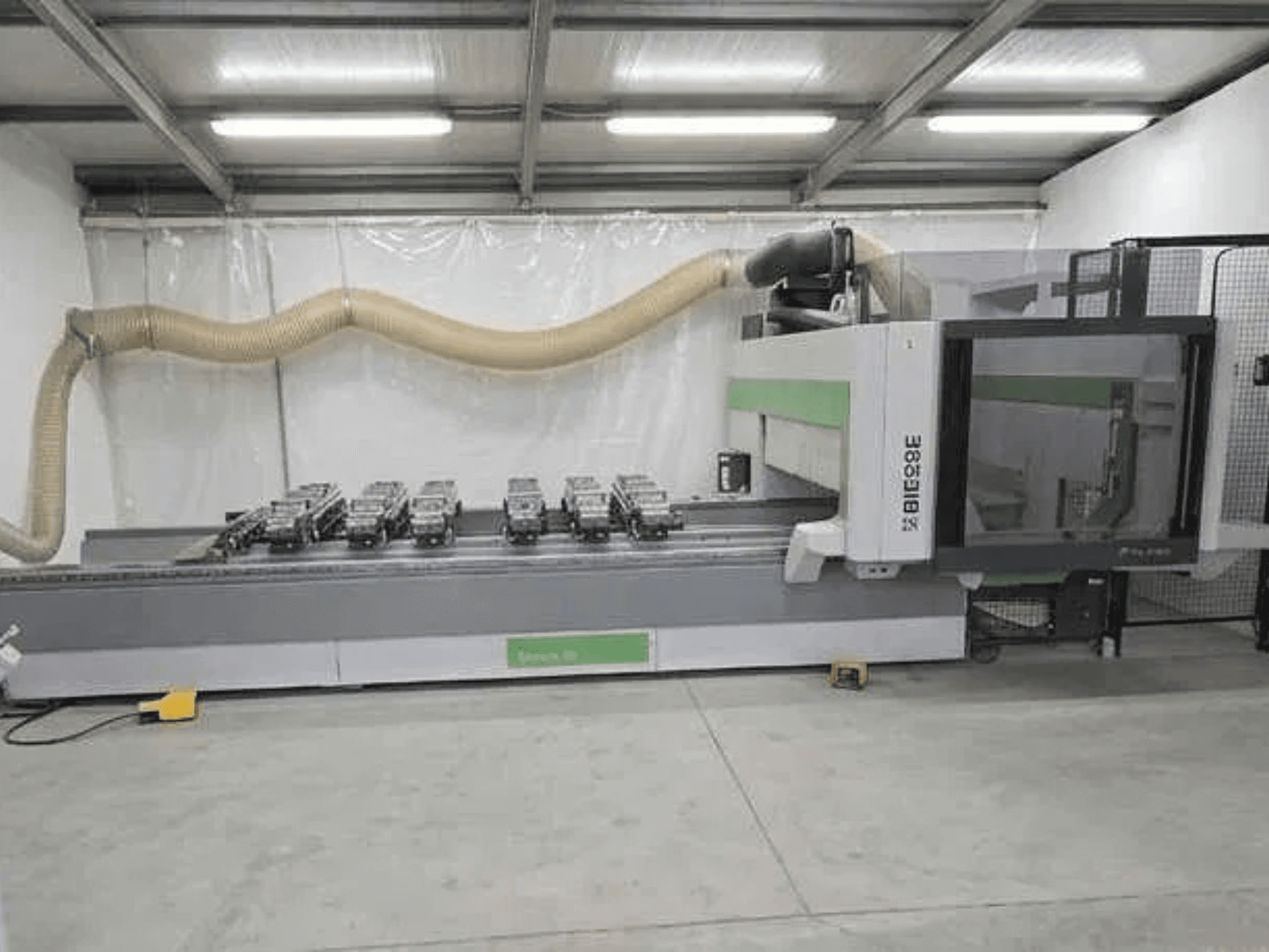 Centro di lavorazione CNC BIESSE Rover K1232 visto di profilo, con ventose a vuoto e sistema di aspirazione delle polveri visibili.