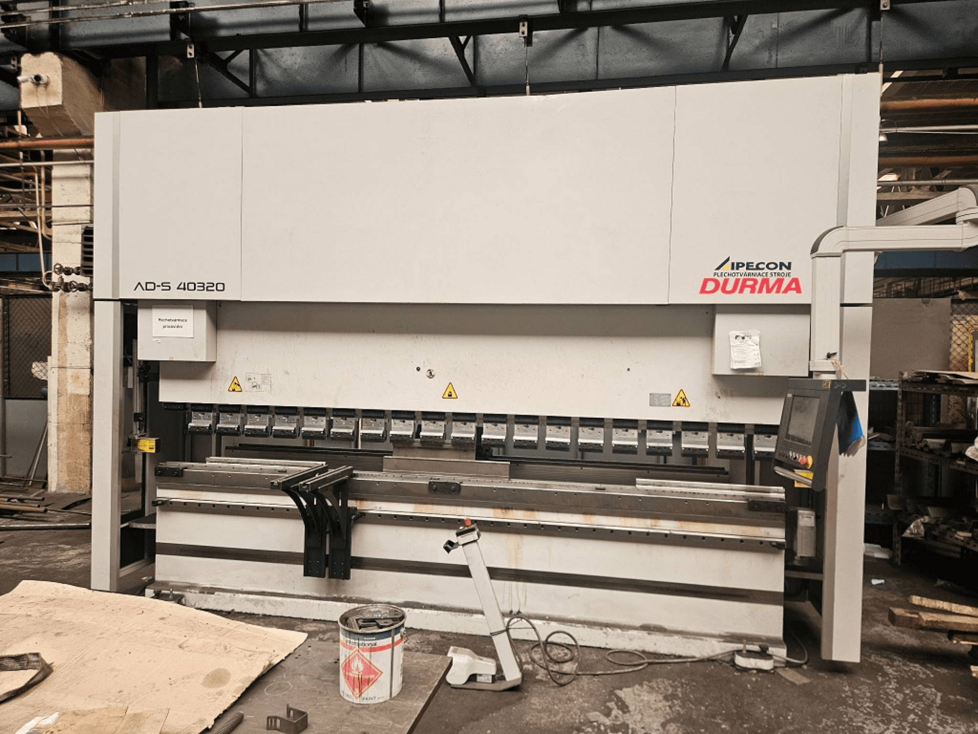 Piegatrice Durma AD-S 40320 vista frontale, con pannello di controllo, utensili di piegatura e avvertenze di sicurezza in un ambiente di officina.