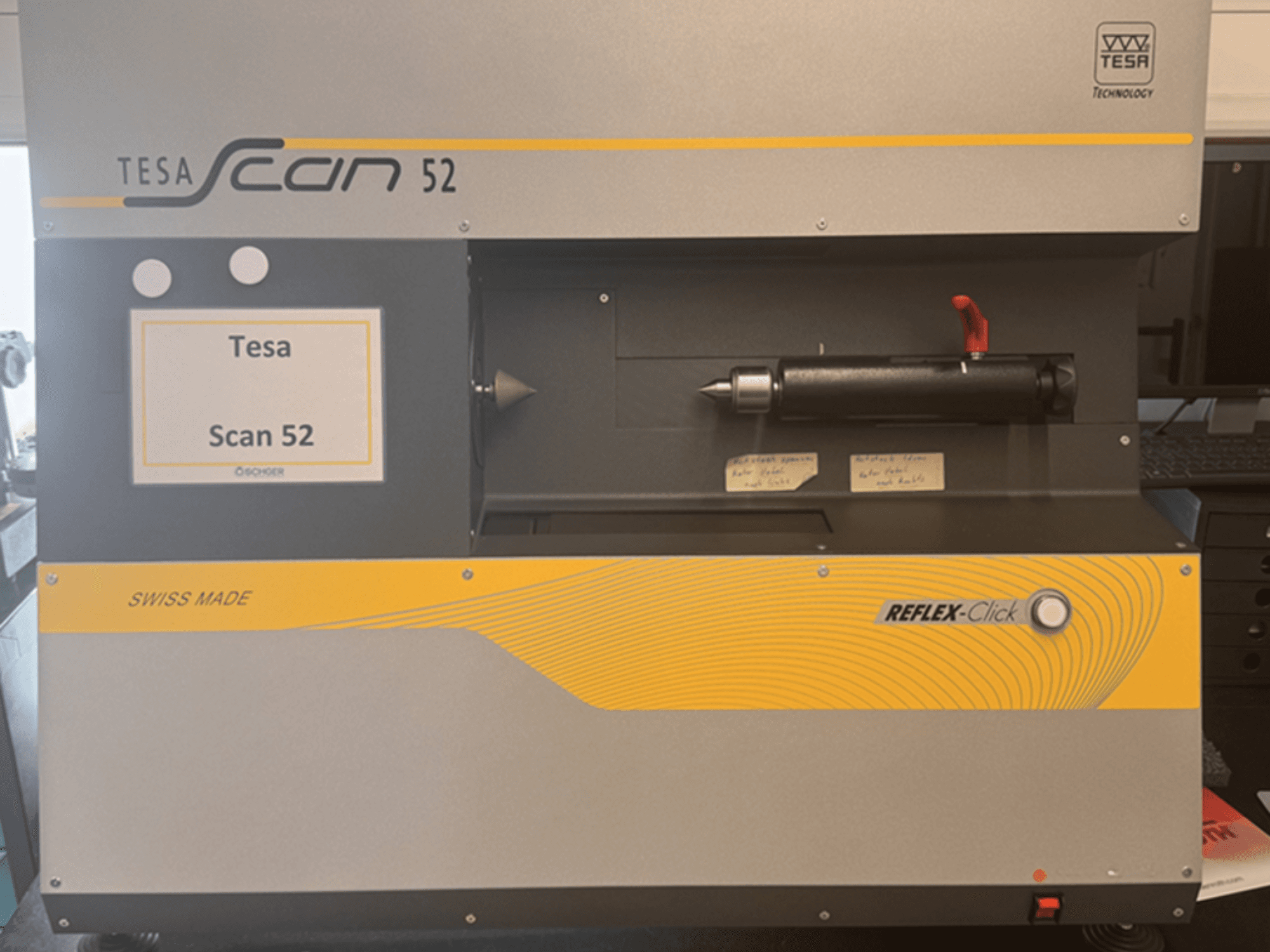 Vista frontale della macchina di misura ottica TESA Scan 52, con i pulsanti di comando e l'etichetta "SWISS MADE" ben visibili.