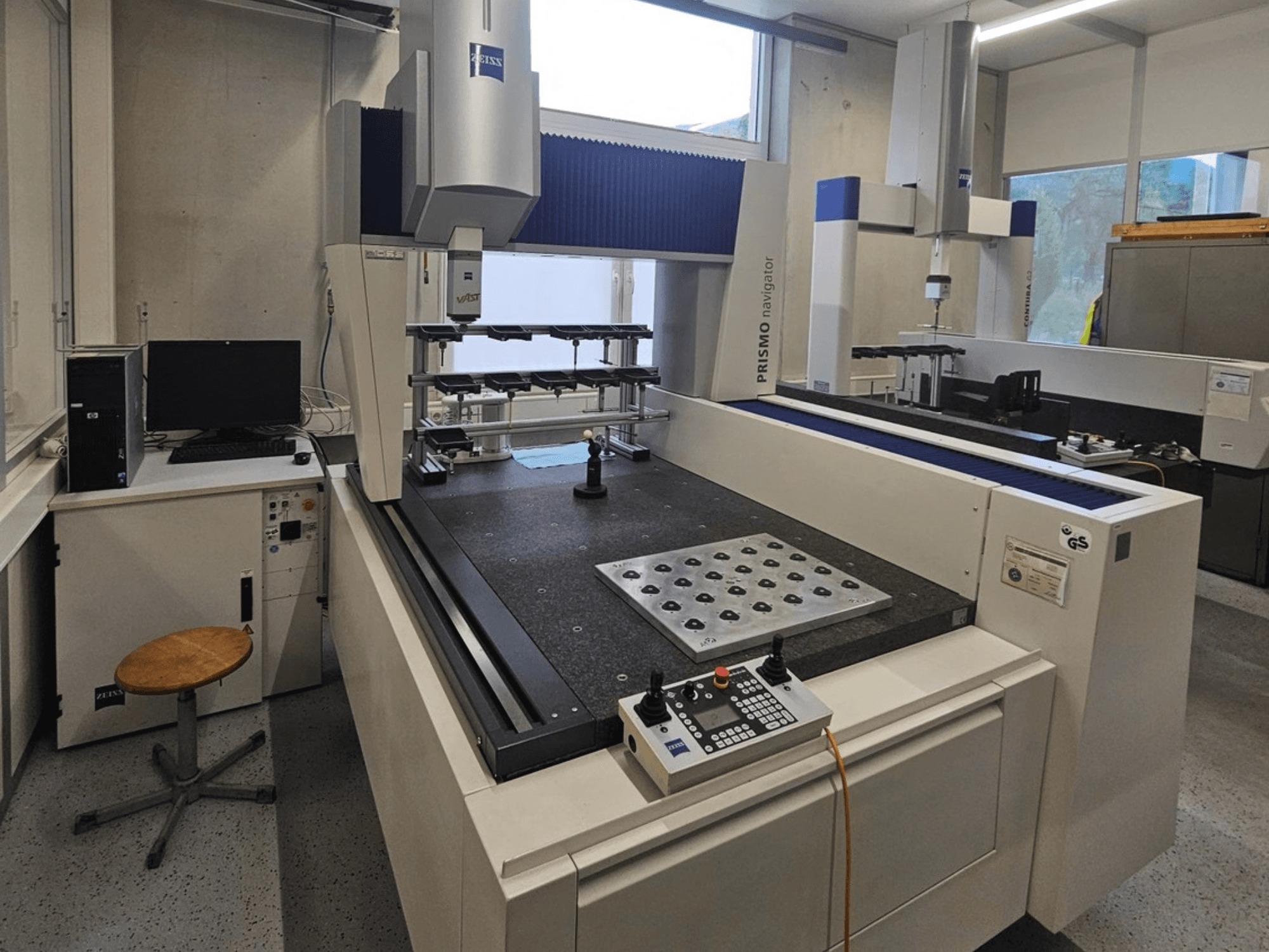 CMM ZEISS Prismo Navigator 7 in un laboratorio: vista frontale che mostra il pannello di controllo, il piano di lavoro e il monitor.