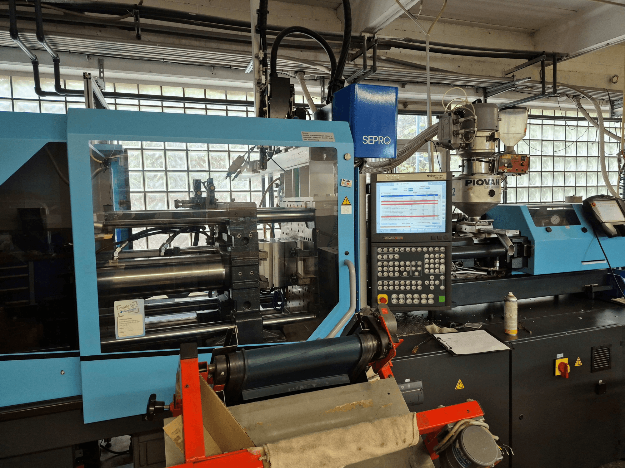 Macchina per lo stampaggio a iniezione idraulica SUMITOMO SHI DEMAG Systec 120/470-430, vista frontale con pannello di controllo e sistema di alimentazione visibili.