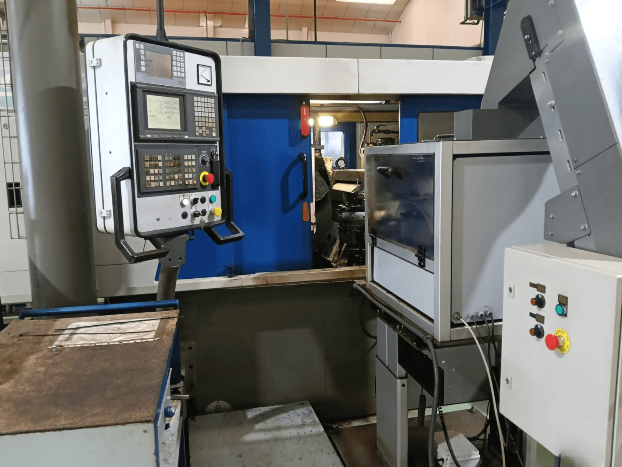 Pannello di controllo e macchinari della rettificatrice senza centri DANOBAT 327 MDA, visti di lato, con pulsanti e display.