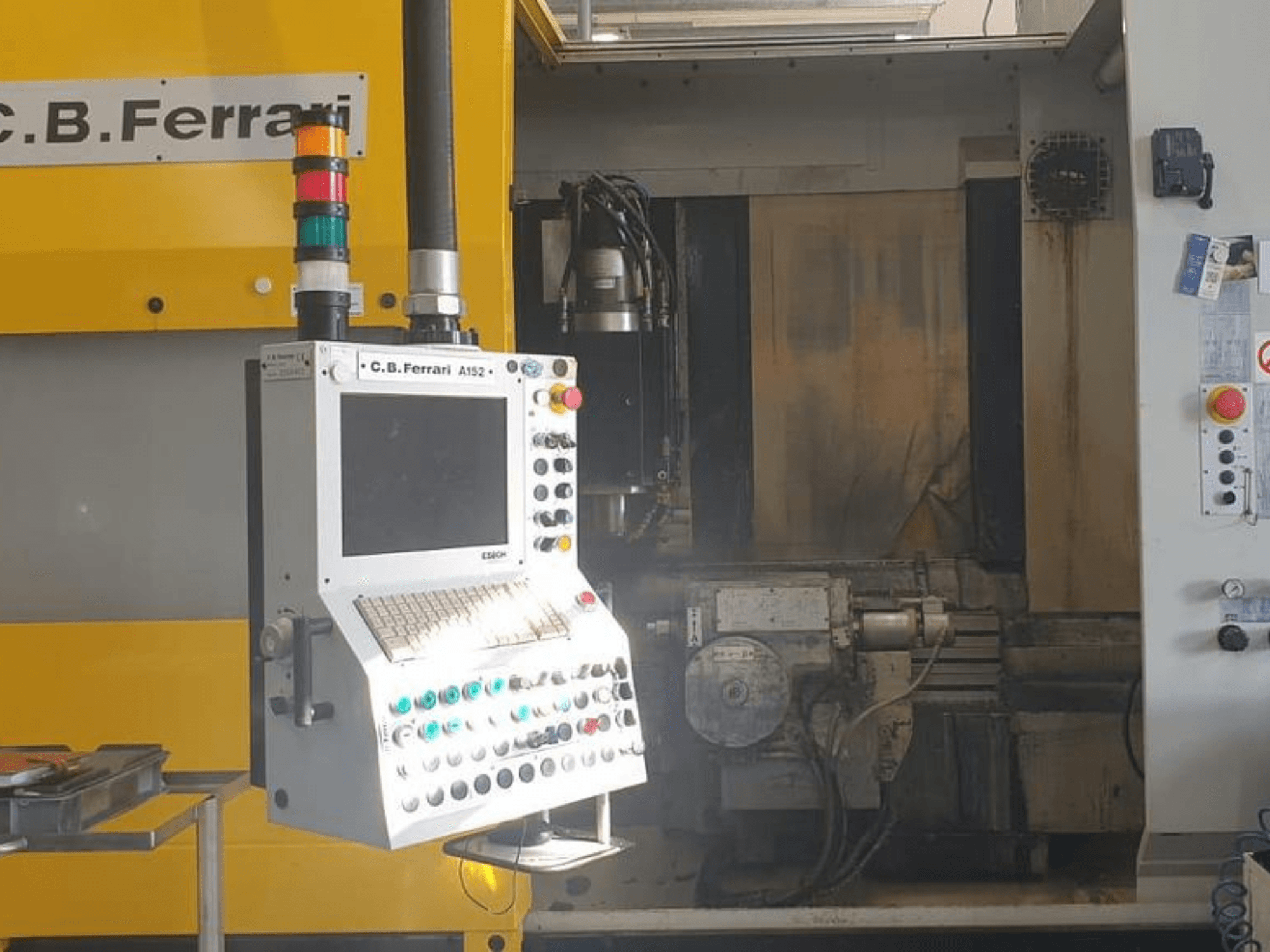 Vista frontale del Centro di lavoro verticale C.B. Ferrari A152, che mostra il pannello di controllo con i pulsanti e i componenti del motore in macchina.