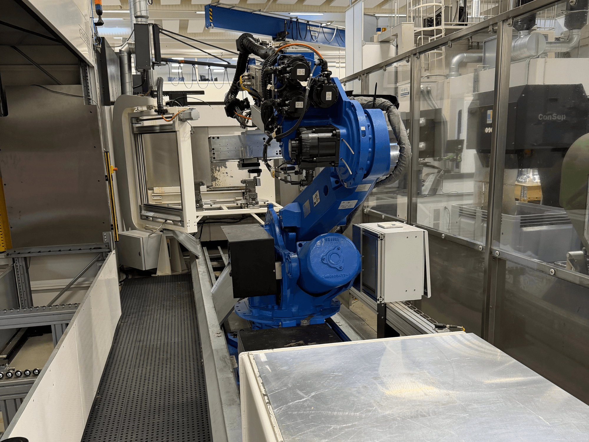 Braccio robotico Yaskawa Motoman ES165D su rotaia, vista laterale che mostra la configurazione dell'automazione in un ambiente industriale.