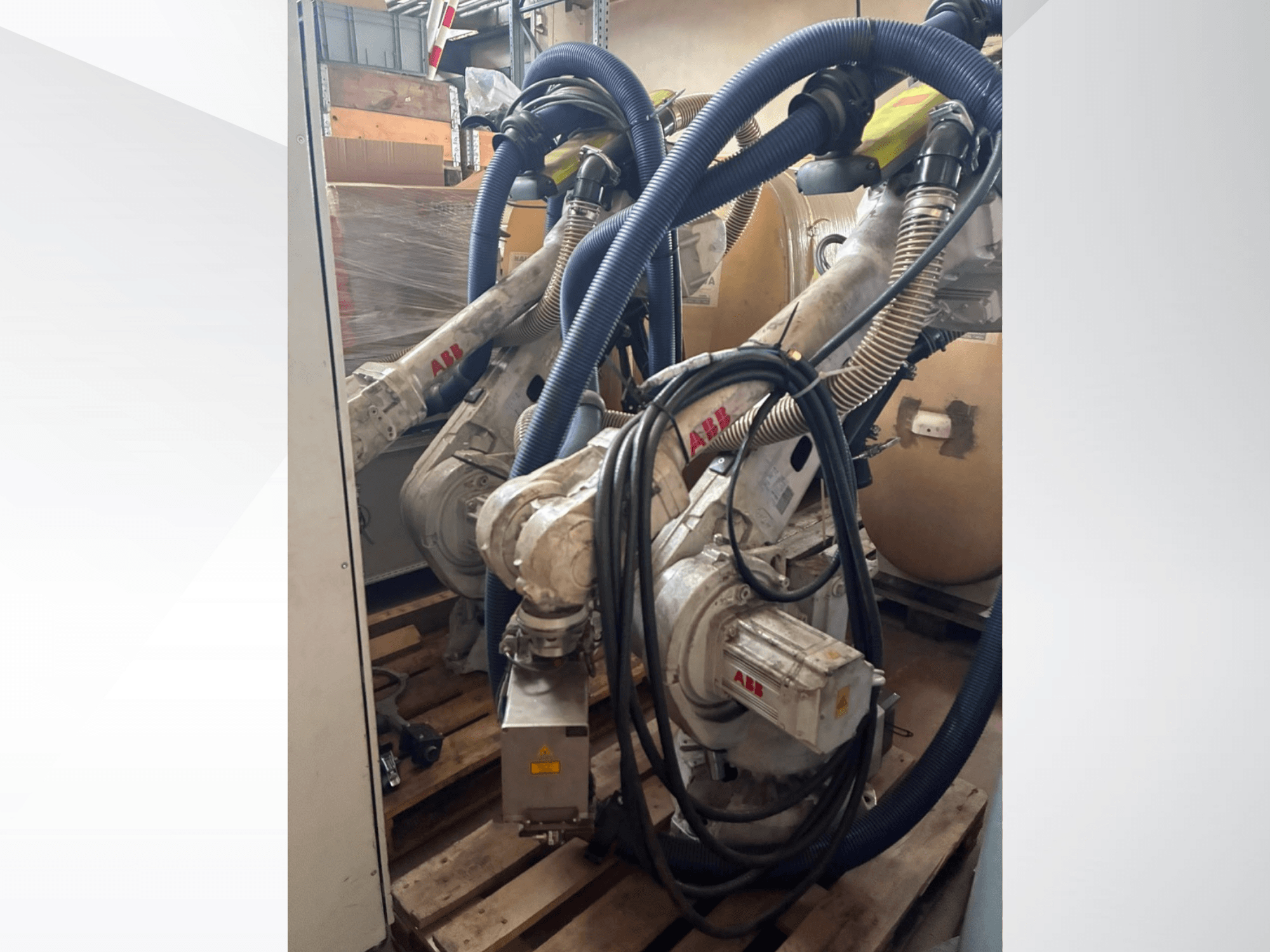 Braccio robotico ABB IRB 4600-40/2.55, vista laterale che mostra i due bracci e i tubi collegati, montato su pallet in un magazzino.