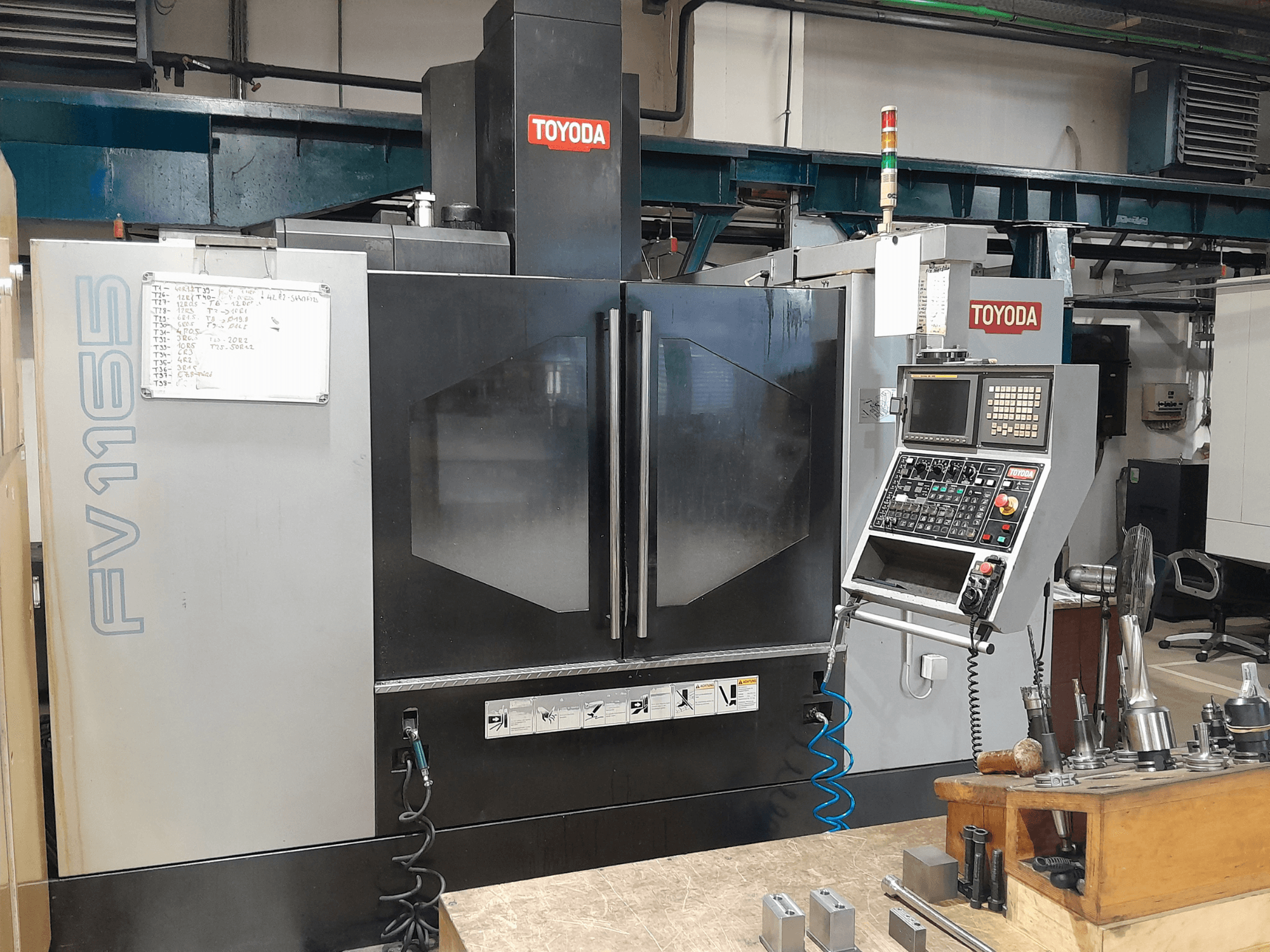 Centro di lavoro verticale TOYODA FV 1165, vista frontale, con pannello di controllo e indicatori operativi.